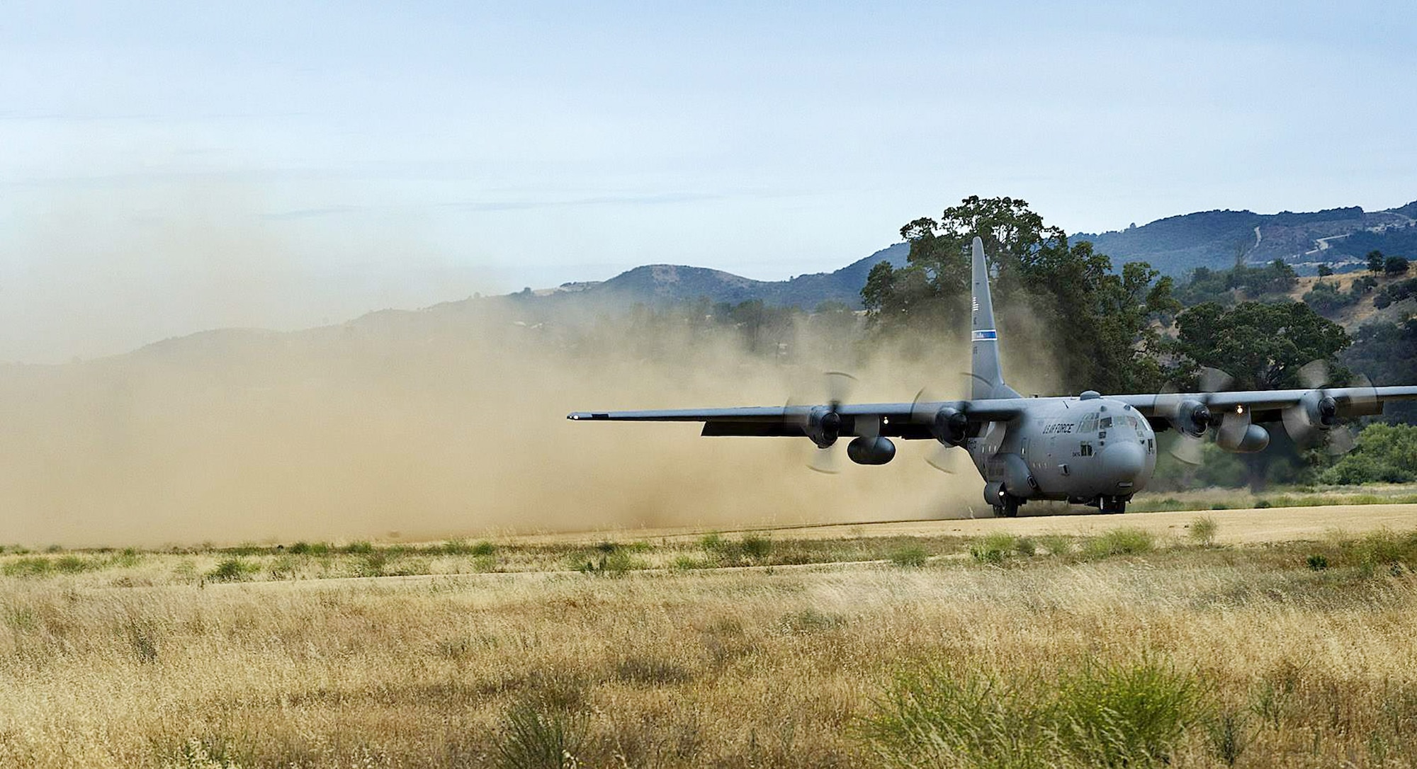 A C-130 Hercules lands on a dirt landing strip on Schoonover Landing Zone at Fort Hunter-Ligget, Calif. during the Hydra Exercise 2009.  Hydra is a training exercise developed to provide a West Coast venue to train the 615 Contingency Response Wing's unique mission capabilities such as, command and control, aerial port, maintenance and air mobility liaison duties in a joint environment.  (U. S. Air Force photo/Master Sgt. Cecilio Ricardo)