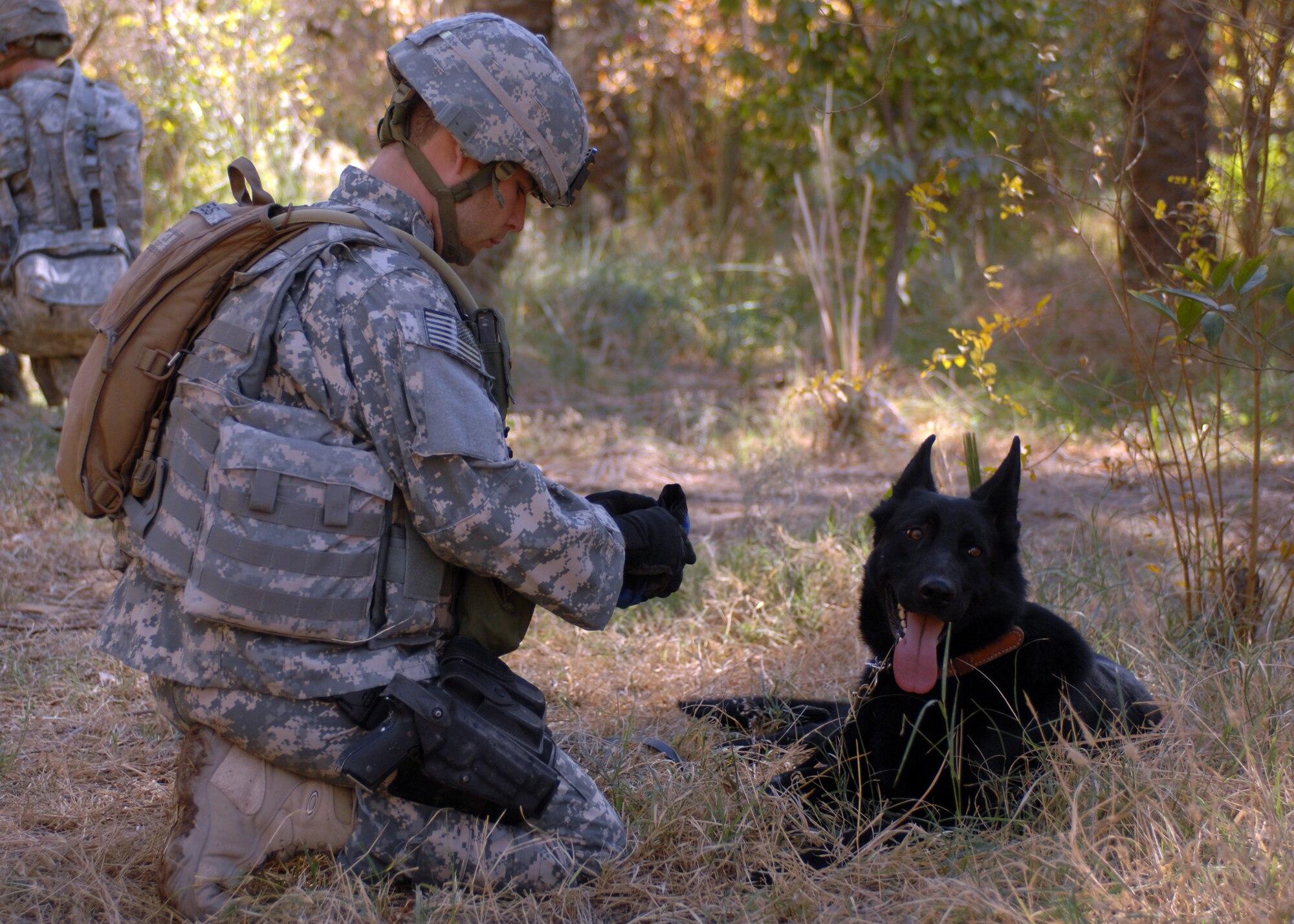 Tech Sgt. Michael Jones and military working dog Blacky pause during patrol in Iraq for a water break. (Courtesy photo)