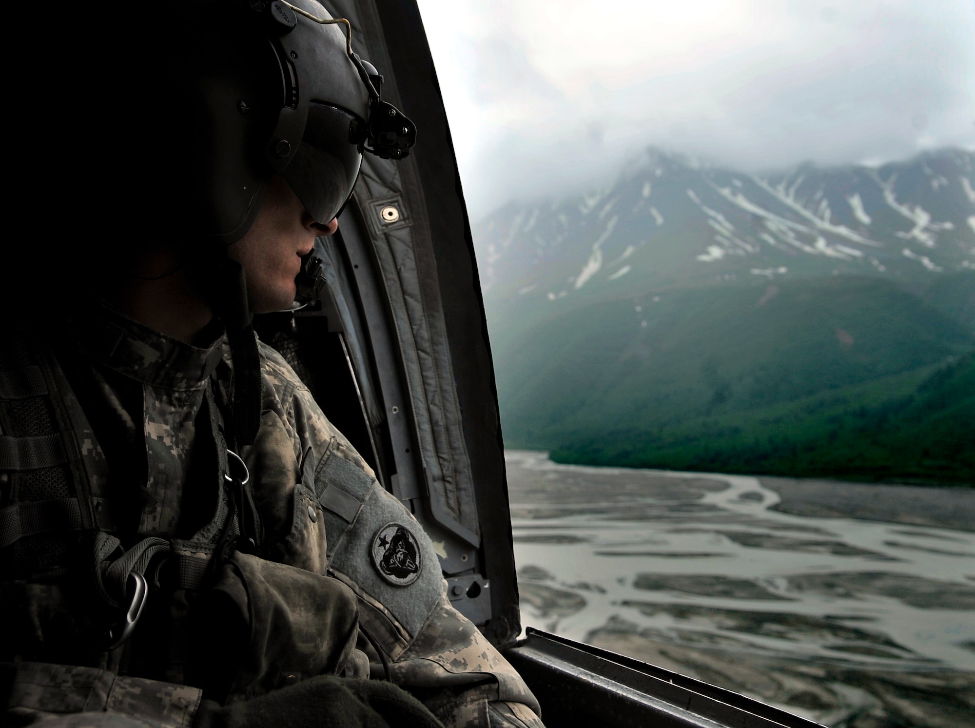 Army Sgt. William Penley looks over the Alaskan terrain in a CH-47 Chinook during NORTHERN EDGE 2009, June 17. NE09 is a large scale exercise hosted in Alaska to improve command, control and communications between the Armed Services. Sergeant Penley is a flight engineer assigned to Bravo Comany 152, Fort Wainwright, Alaska. (U.S. Air Force photo/Staff Sgt. Christopher Boitz)