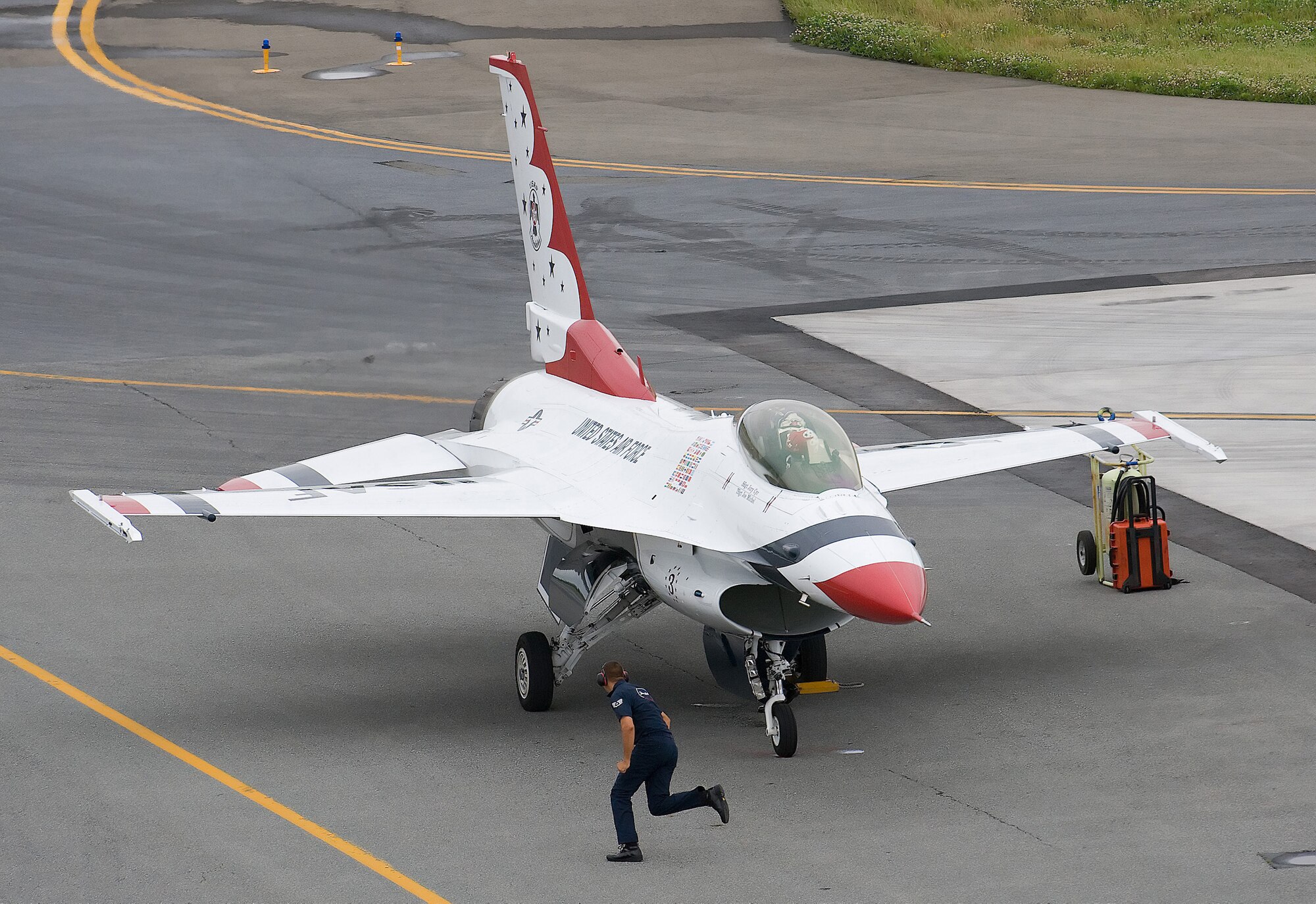 A U.S. Air Force Thunderbird crewchief scurries to assist a Thunderbird F-16 Falcon pilot park at Dover Air Force Base, Del., June 18. The Thunderbirds will headline in the base?s Open House and Air Show June 20 and 21. (U.S. Air Force Photo/Jason Minto)