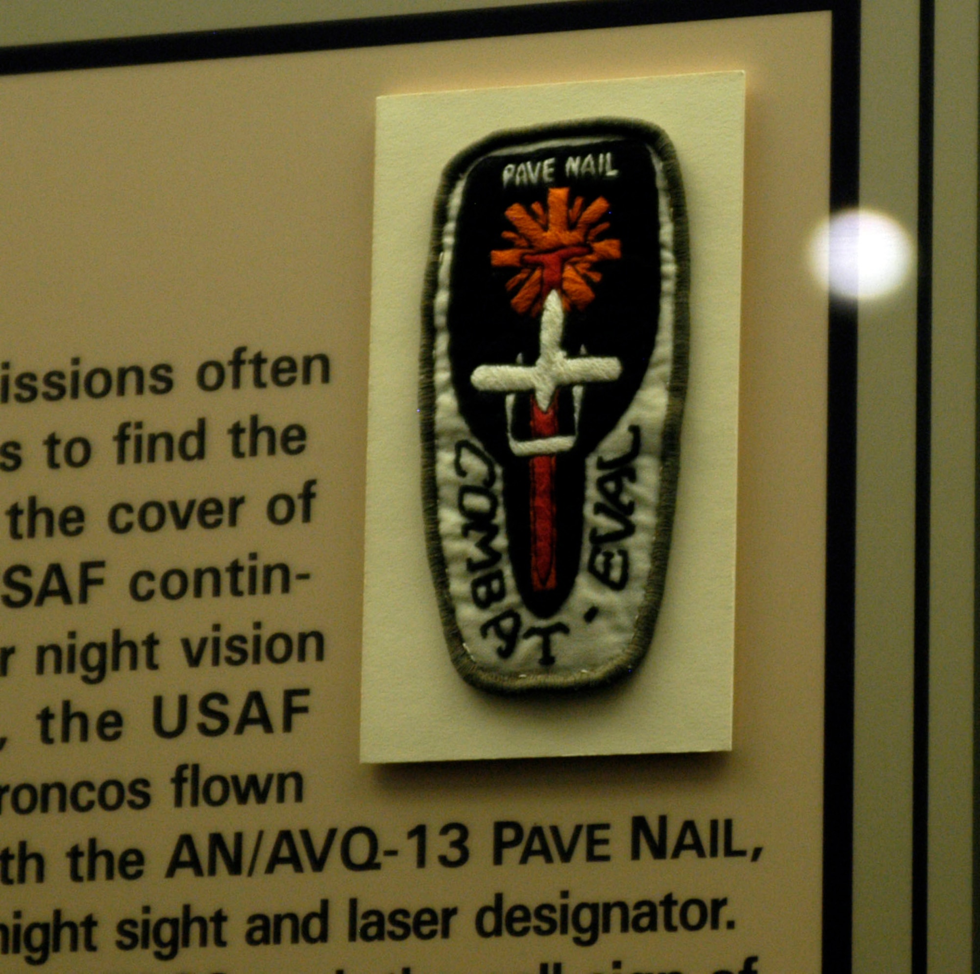 DAYTON, Ohio - FACs flying night missions often used Starlight scopes to find the enemy hiding under the cover of darkness, but the USAF continued looking for better night vision systems. In 1971, the USAF equipped the OV-10 Broncos flown by the 23rd TASS with the AN/AVQ-13 PAVE NAIL, a stabilized periscopic night sight and laser designator. Not surprisingly, the 23rd TASS took the call sign of Nail. This patch shows an OV-10 over a red nail, and the black patch indicates the darkness of night. (U.S. Air Force photo)