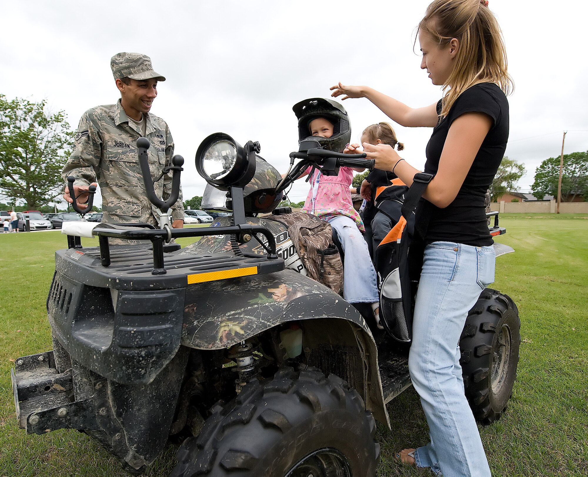 Airman 1st Class Paul Jordan, 436th Civil Engineer Squadron, talks to a family about the uses for the military All-Terrain Vehicle during the Children?s Mobility Line June 17.  The event was held to help children understand the process of being deployed and the equipment their parents use downrange.  (U.S. Air Force photo/Thomas Randle)