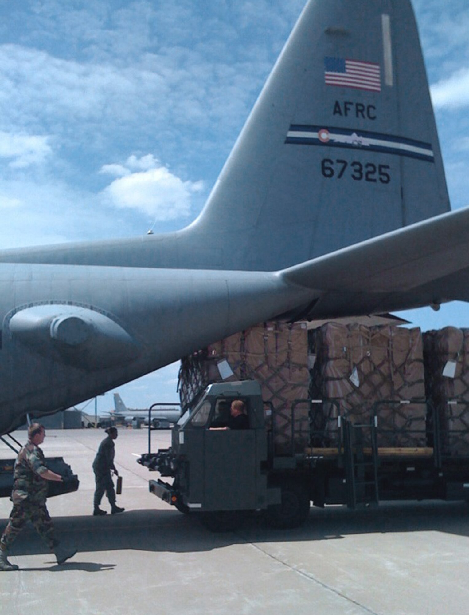 Members of the 185th Air Mobility Wing begin loading four crates of children's wheelchairs onto a C-130 Hercules June 11, in Sioux City, Iowa. A C-130 aircrew from Air Force Reserve Command's 302nd Airlift Wing, Peterson Air Force Base, Colo., transported the wheelchairs to Andrews AFB, Md., where a larger cargo plane transported the wheelchairs to Baghdad, Iraq. (U.S. Air Force photo/Capt. Brian McReynolds)
