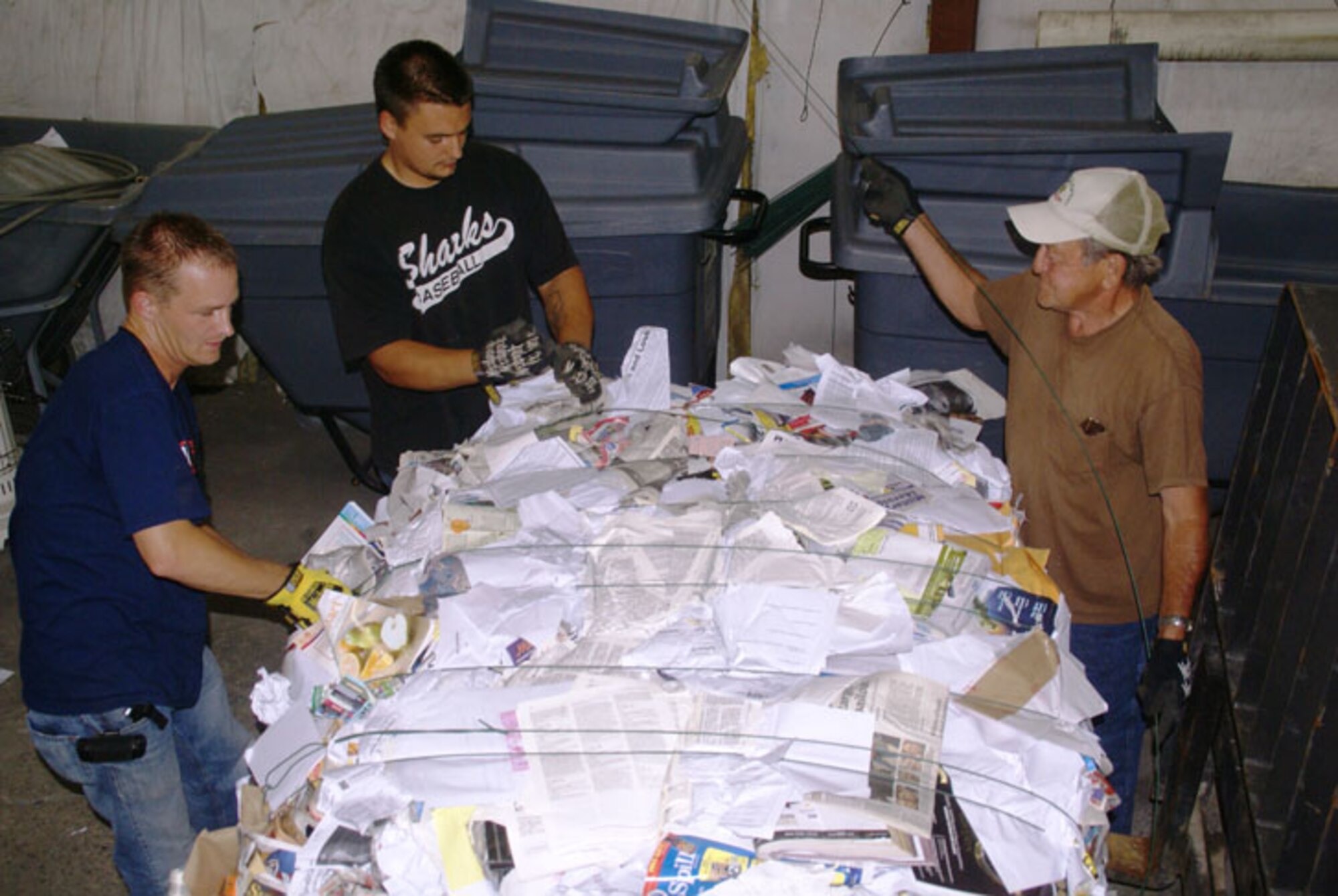 From left, Robbie Evans, Bronson Kindermann and Stanley Hill bale a load of mixed paper at the base Services Recycling Center as part of the Arnold Engineering Development Center's Resource Recovery and Recycling Program. Evans, a base Services motor vehicle operator and lead of the three-man team, said recyclable paper, cardboard, plastic and aluminum is collected, sorted, packaged, stored and eventually sold to outside vendors. The money generated from the sales goes toward maintaining and sustaining the equipment needed for the recycling process, with some of the funds going into a non-appropriated account for base Service programs. (Photo by Philip Lorenz III)