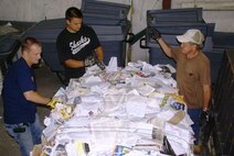From left, Robbie Evans, Bronson Kindermann and Stanley Hill bale a load of mixed paper at the base Services Recycling Center as part of the Arnold Engineering Development Center's Resource Recovery and Recycling Program. Evans, a base Services motor vehicle operator and lead of the three-man team, said recyclable paper, cardboard, plastic and aluminum is collected, sorted, packaged, stored and eventually sold to outside vendors. The money generated from the sales goes toward maintaining and sustaining the equipment needed for the recycling process, with some of the funds going into a non-appropriated account for base Service programs. (Photo by Philip Lorenz III)
