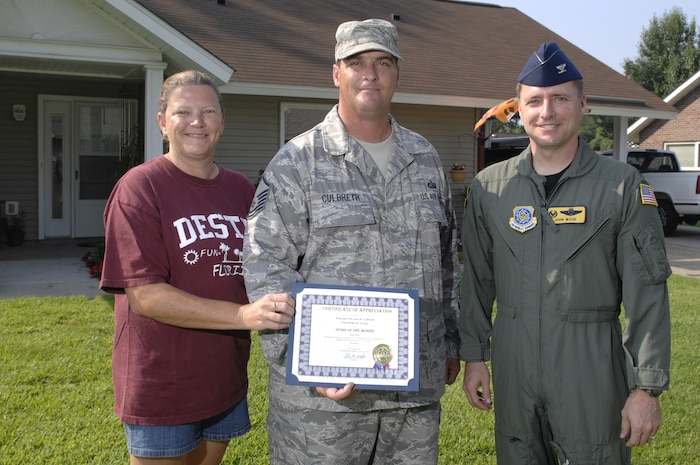 Col. Wood presents Master Sgt. Joel Culbreath and his wife Debbie with a Yard of the Month certificate. The friendly competition between neighbors encourages base housing residents to take pride in their yards. Colonel Wood is the 437th Airlift Wing commander and Sergeant Culbreath is a member of the 437th Communications Squadron. (U.S. Air Force photo/James M. Bowman)