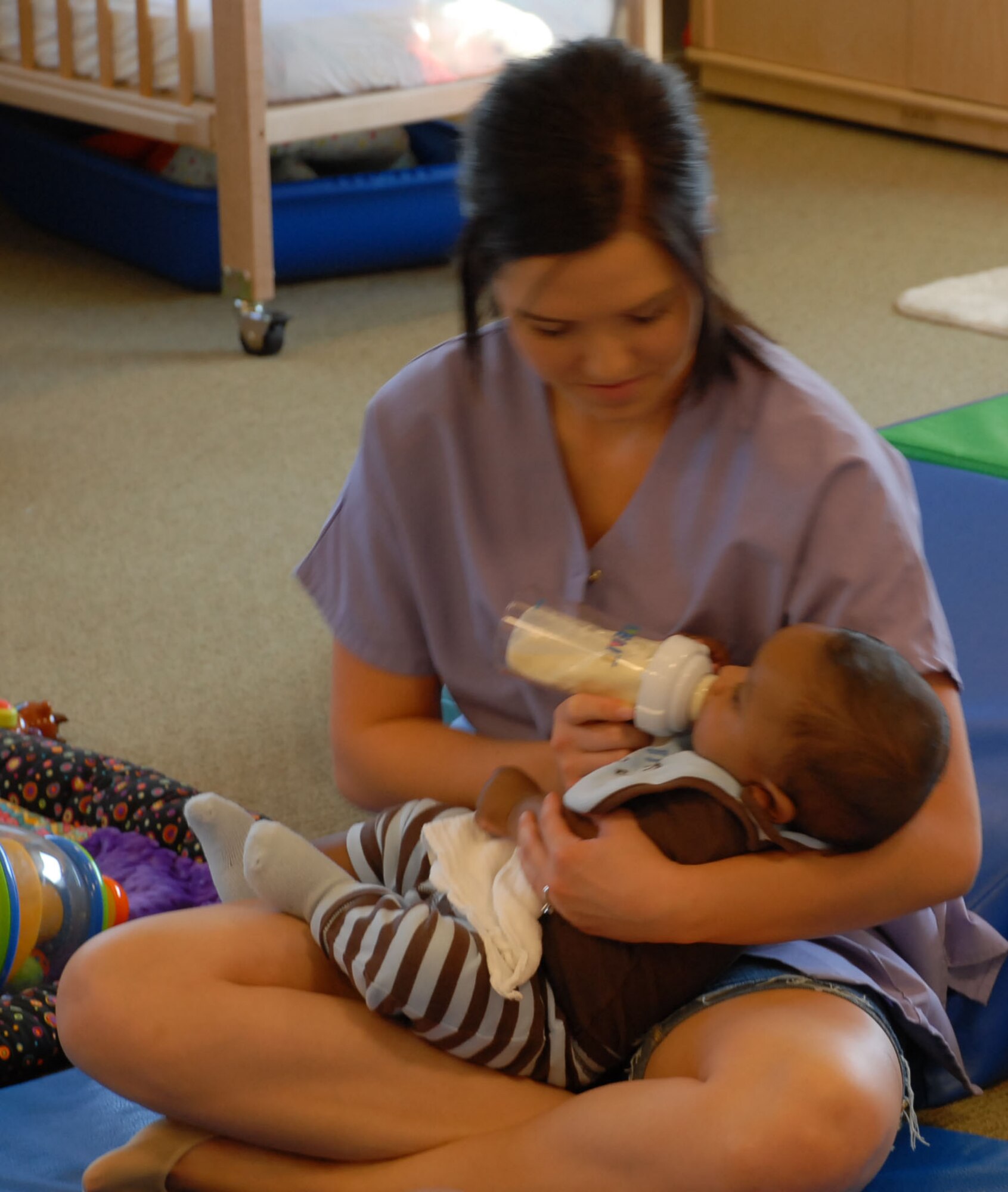 Catherine Rowles, a 9th FSS CDC teacher, feeds an infant June 17 at the CDC. Teachers provide high-quality care to children ages six weeks to five years old. (Photo by Airman 1st Class Chuck Broadway)