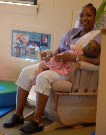 Josephine Holmes, 9th Force Support Squadron Child Development Center teacher, rocks an infant to sleep June 17 at the CDC. The CDC employs 66 people including teachers, kitchen workers and receptionists. (Photo by Airman 1st Class Chuck Broadway)