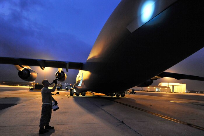 Senior Airman Kyle Robinson uses a flashlight to inspect the exterior of a C-17 for missing screws or damage to the aircraft June 18, 2009, at Charleston Air Force Base, S.C. Airman Robinson is a crew chief with the 315th Aircraft Maintenance Squadron. (U.S. Air Force photo/James M. Bowman) (RELEASED)