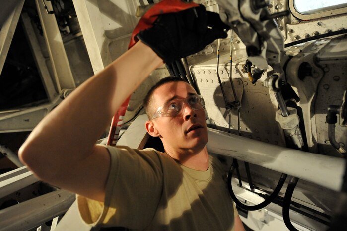 Senior Airman James Witherspoon installs a main landing gear safety downlock pin on a C-17 aircraft June 18, 2009, at Charleston Air Force Base, S.C. Airman Witherspoon is a crew chief with the 315th Aircraft Maintenance Squadron. (U.S. Air Force photo/James M. Bowman) (RELEASED)