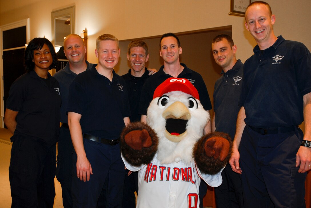 "Screech," the Washington National's mascot, shares the camera with members of the Air Force Band's Max Impact at the 459th Air Refueling Wing Yellow Ribbon welcome home event. Members of the 459th ARW who recently returned from deployment attended the event to learn more information about services available to them post-deployment and assistance reintegration back into the civilian world. (U.S. Air Force Photo/ Senior Airman Sasha S. Skirne)