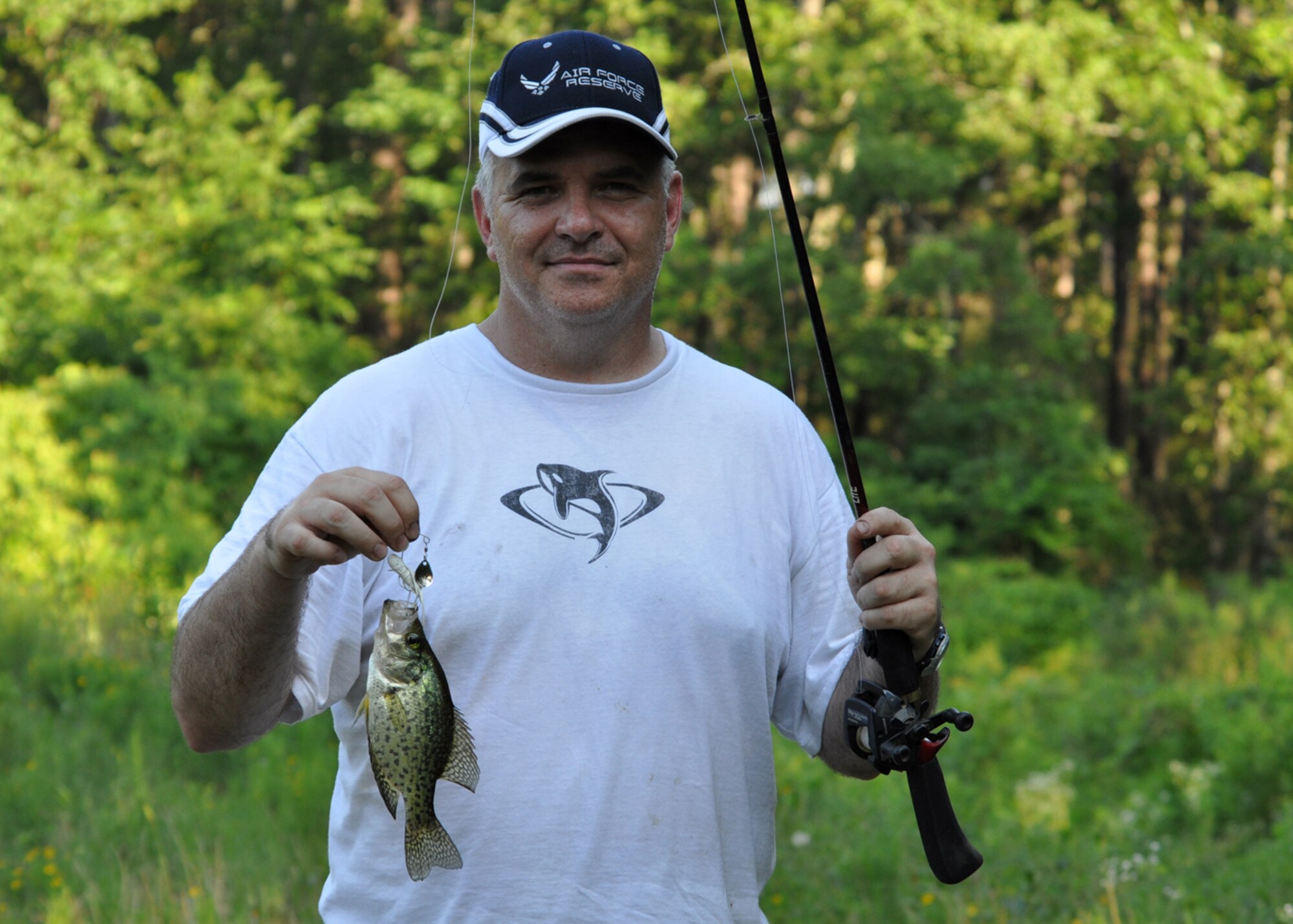 Master Sgt. Greg Steele, 47th Fighter Squadron, visual information technician, beams with pride at his only catch for the day at a small pond on the East Reservation of Barksdale Air Force Base, La., June 13, 2009. Sergeant Steele took his children out to the East Reservation of Barksdale to enjoy a fun-filled day of fishing and peanut butter and jelly sandwiches. Sergeant Steele is an Air Reserve Technician with the 47th FS. (Courtesy photo)