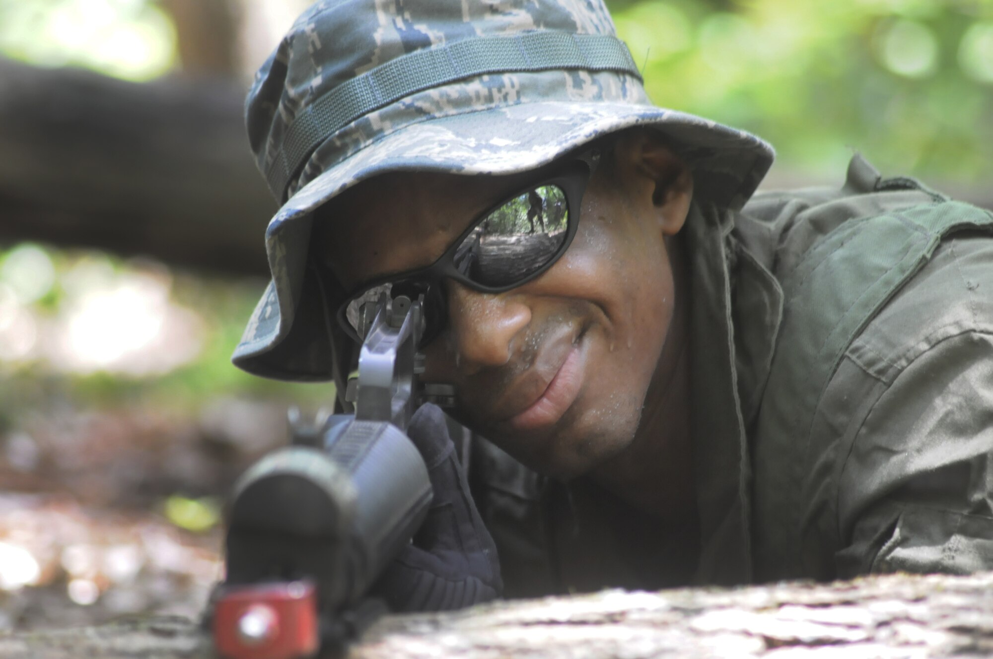 Cadet Christopher Daniels takes a position with a M-16 in the woods at Warrior Air Base June 12. The cadets acted as aggressors while taking part in 5th CCG Gator Gully training. U. S. Air Force photo by Sue Sapp