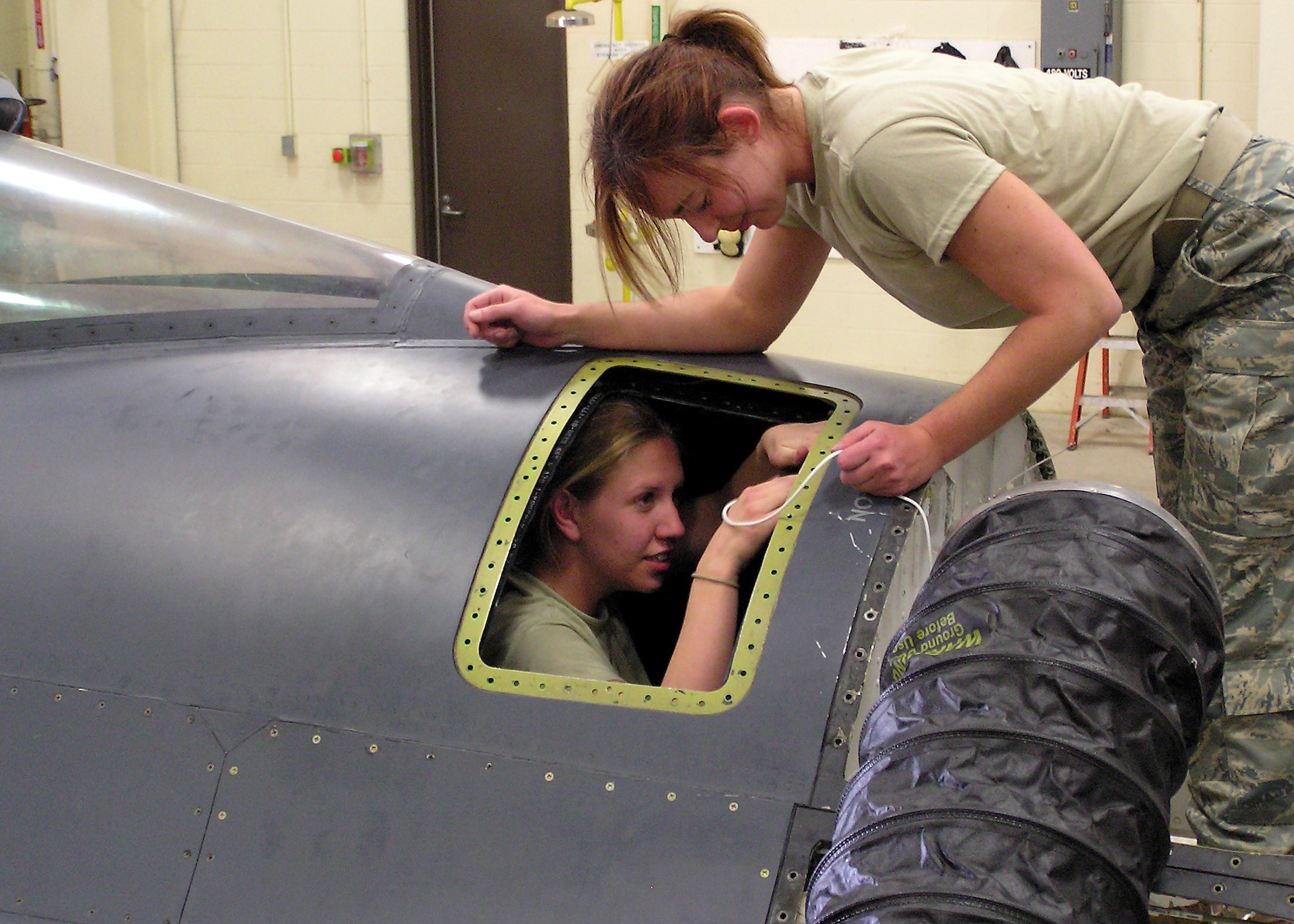 Staff Sgt. Deidra Braun and Tech. Sgt. Annmarie Schneider work to resolve a fuel cell problem that was found during routine maintenance on an F-16. The problem is being evaluated on every F-16 assigned to Traux Field. ((Photo by Master Sgt. James Hale)
