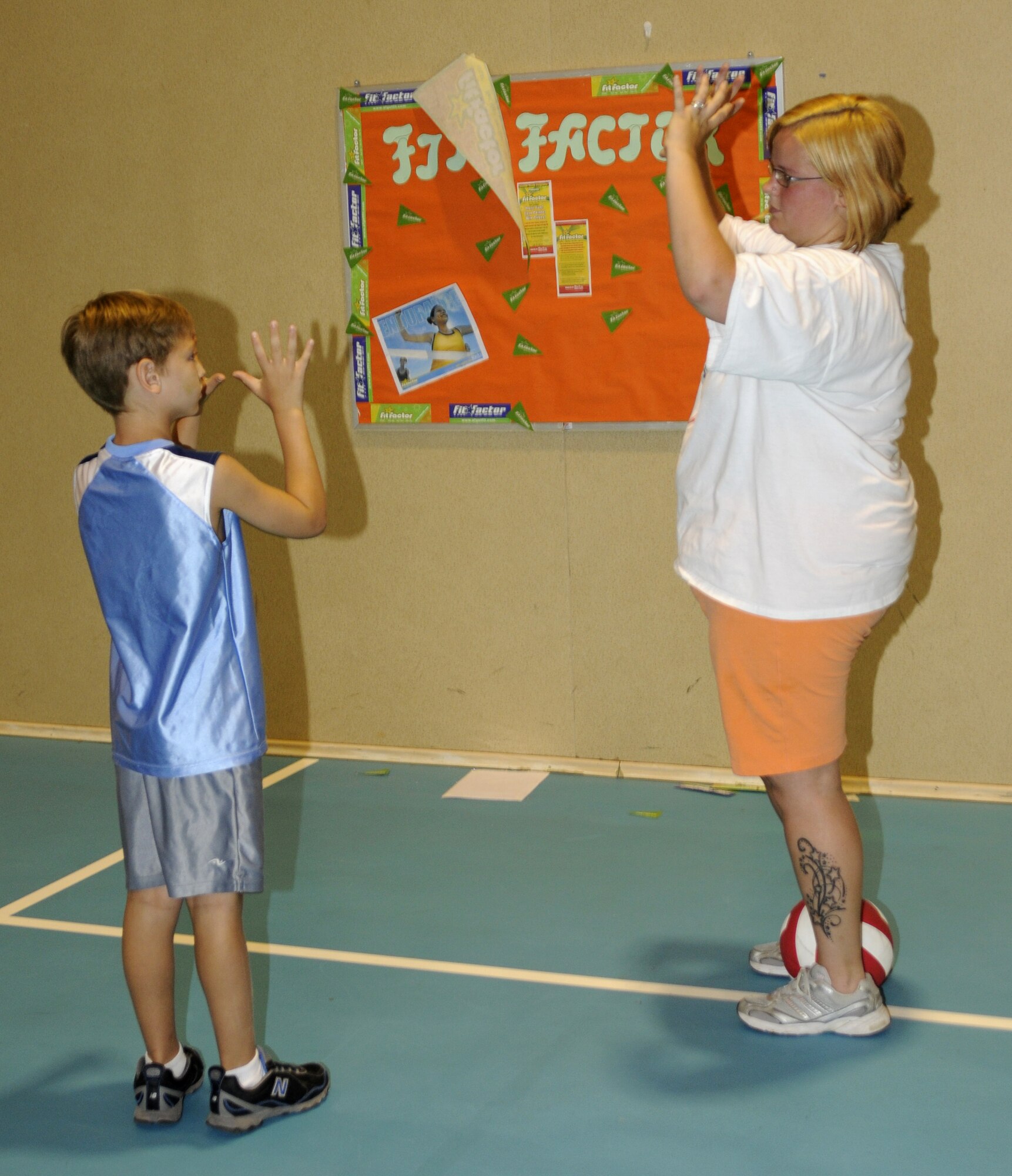 Stayce Osbourne, 39th Air Base Wing Youth Programs recreation assistant, shows Isaac Tullis, son of Tech. Sgt. Kent Tullis, 39th Medical Group, how to place his hands while trying to “set” a volleyball during a game at the YP volleyball camp Tuesday, June 16, 2009 at Incirlik Air Base, Turkey. The camp, which runs the entire week, is just one on a list of several camps and recreation trips available for children during their summer. Call YP at 676-6670 for more information about activities.  (U.S. Air Force photo/Airman 1st Class Amber Russell)