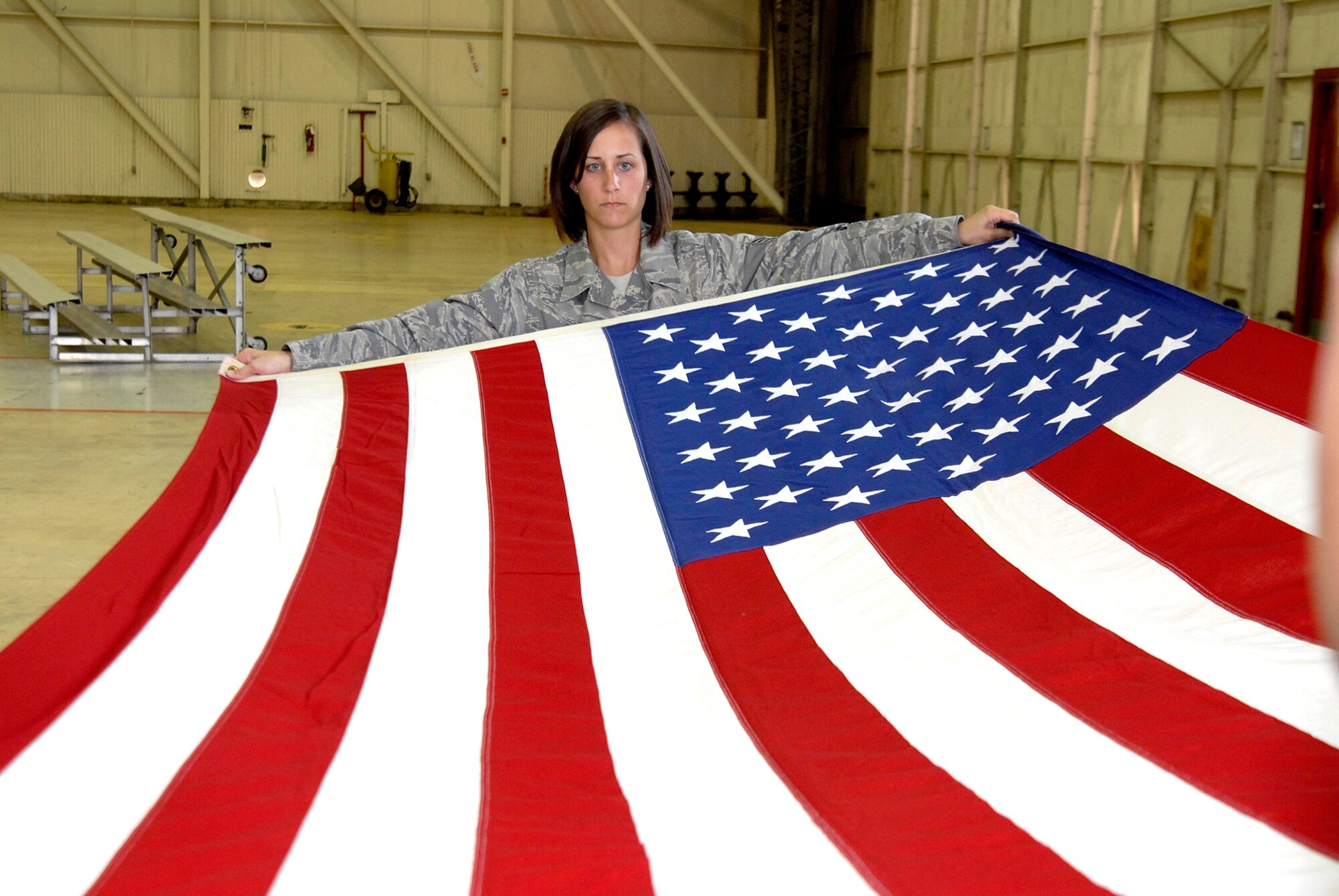 Staff Sgt Amanda Hibbler, 8th Fighter Wing Judge Advocates Office, presents the American Flag as part of a flag folding ceremony while participating in Honor Guard practice at Kunsan Air Base, Republic of Korea, June 3. Kunsan's Honor Guard performs ceremonies ranging from change of command ceremonies to retirements. (U.S. Air Force Photo by SSgt Jason Colbert)