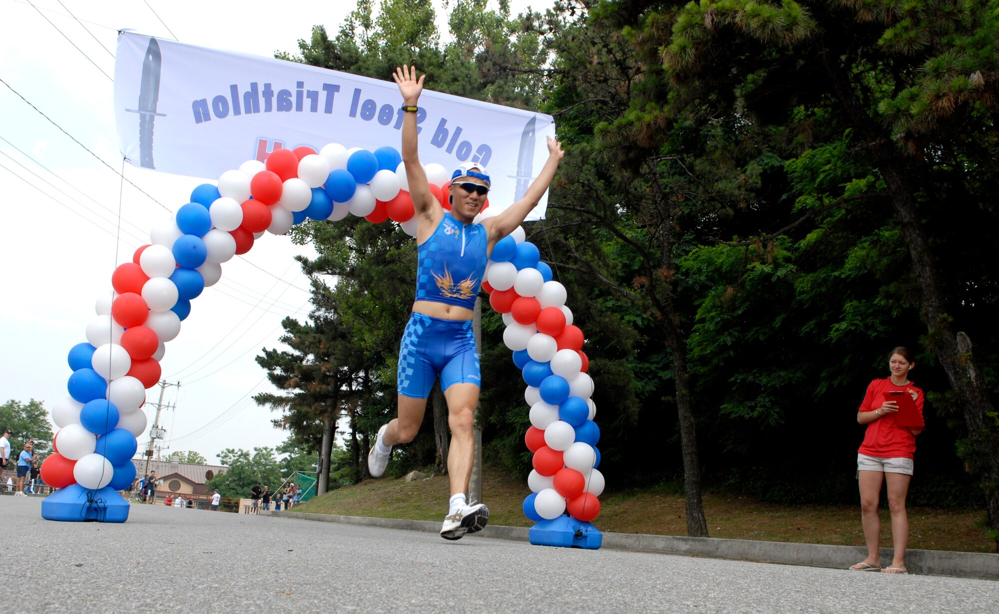 A Cold Steel Triathlon participant crosses the finish line after a 5K run to conclude the event June 13, at Osan Air Base, Republic of Korea. This is the second annual Cold Steel Triathlon hosted by the 3rd Battlefield Coordination Detachment - Korea (BCD-K).  More than 65 U.S., Korean, military and civilian contestants from across the peninsula competed in this event in order to test their physical and mental endurance. The triathlon consisted of a 400 meter swim, 12.4 miles bike race and 5k run. (U.S. Air Force photo/Staff Sgt Brian Ferguson)