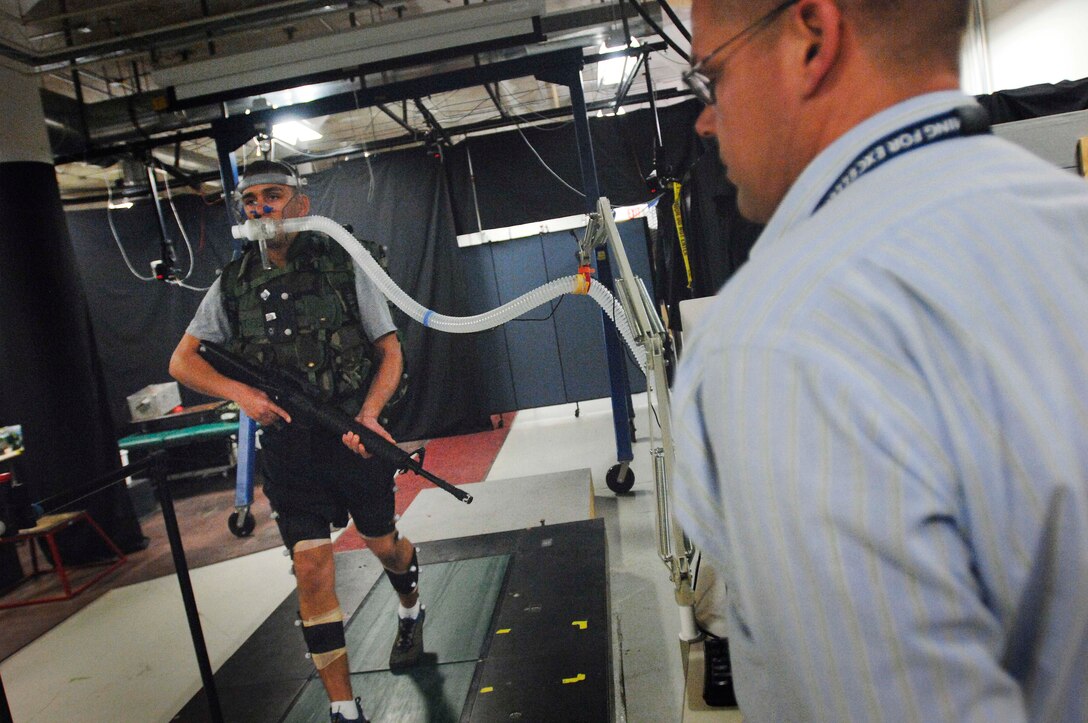 Army Sgt. Michael Cavallo, a research assistant at the U.S. Army Research Institute of Environmental Medicine in Natick, Mass., walks on a patented, force-sensing treadmill invented at the lab. Dr. Joseph Seay monitors Cavallo’s efforts. Systems are attached to measure oxygen consumption to determine locomotion efficiency. DoD photo by Fred W. Baker III