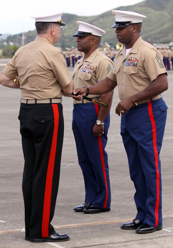 Sgt. Maj. Evans McBride (right)returns the sword of office to Lt. Gen. Keith J. Stalder (left), commanding general, U.S. Marine Corps Forces, Pacific, as he passes on his duties to Sgt. Maj. James Futrell (center) during a ceremony at the MCBH flightline June 19.