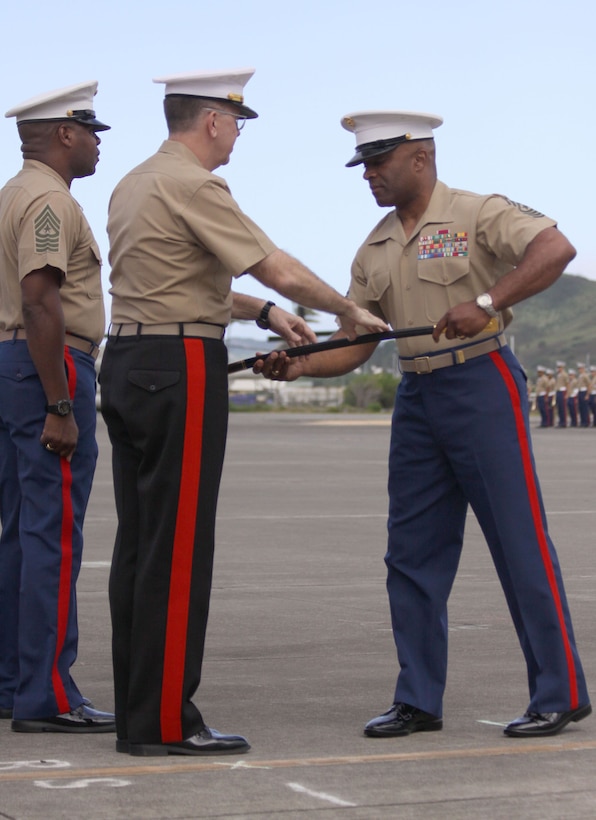 Sgt. Maj. James Futrell (right), newly-appointed sergeant major of U.S. Marine Corps Forces, Pacific, accepts the sword of office from Lt. Gen. Keith J. Stalder (lefT), commanding general MarForPac, during a ceremony at the MCBH flightline June 19.