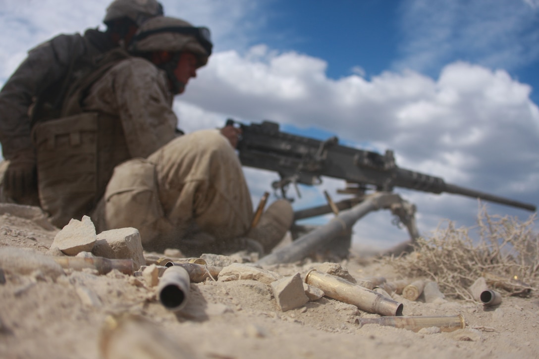 Spent .50 caliber shell casings lay on the ground as Lance Cpl. Chris Cartwright, a rifleman with Weapons Company, 1st Battalion, 23rd Marine Regiment, fires rounds down range  July 19 at Army Ammunition Depot Hawthorne, Nev.