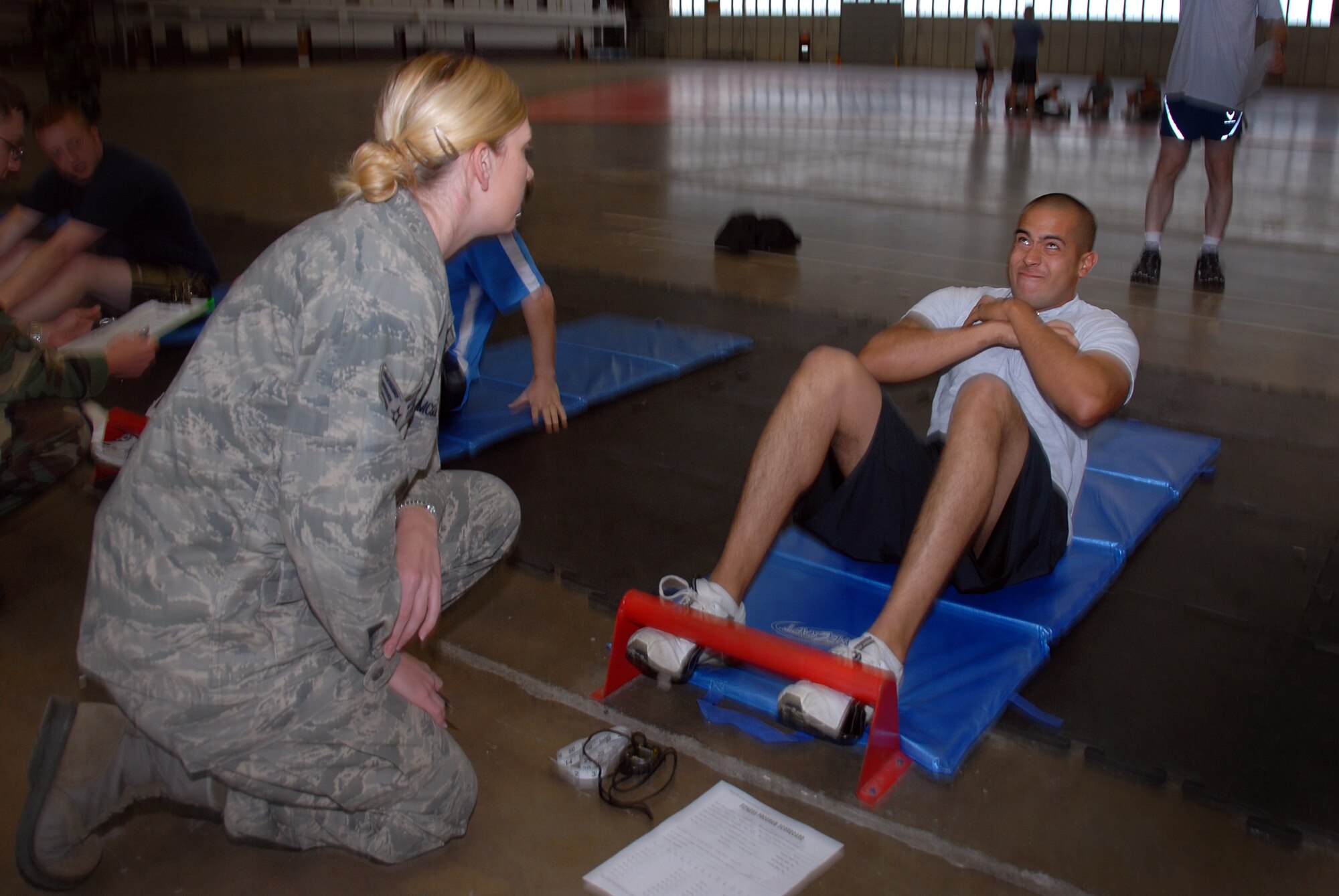 Senior Airman Hannah McGuire with the 28th Medical Group counts as Airman First Class Alex Carmona of the 137th Space Warning Squadron completes his sit-ups during his annual physical training (PT) June 10, 2009, Ellsworth Air Force Base, South Dakota.  Carmona along with other members of the 137th SWS located in Greeley Colorado, are participating in several training events to include there PT test while at Ellsworth AFB this week to further enhance their one of a kind worldwide capable mission as a missile warning , space launch and detection mobile unit. (U.S Air Force photo by: Tech. Sgt. Wolfram M. Stumpf)