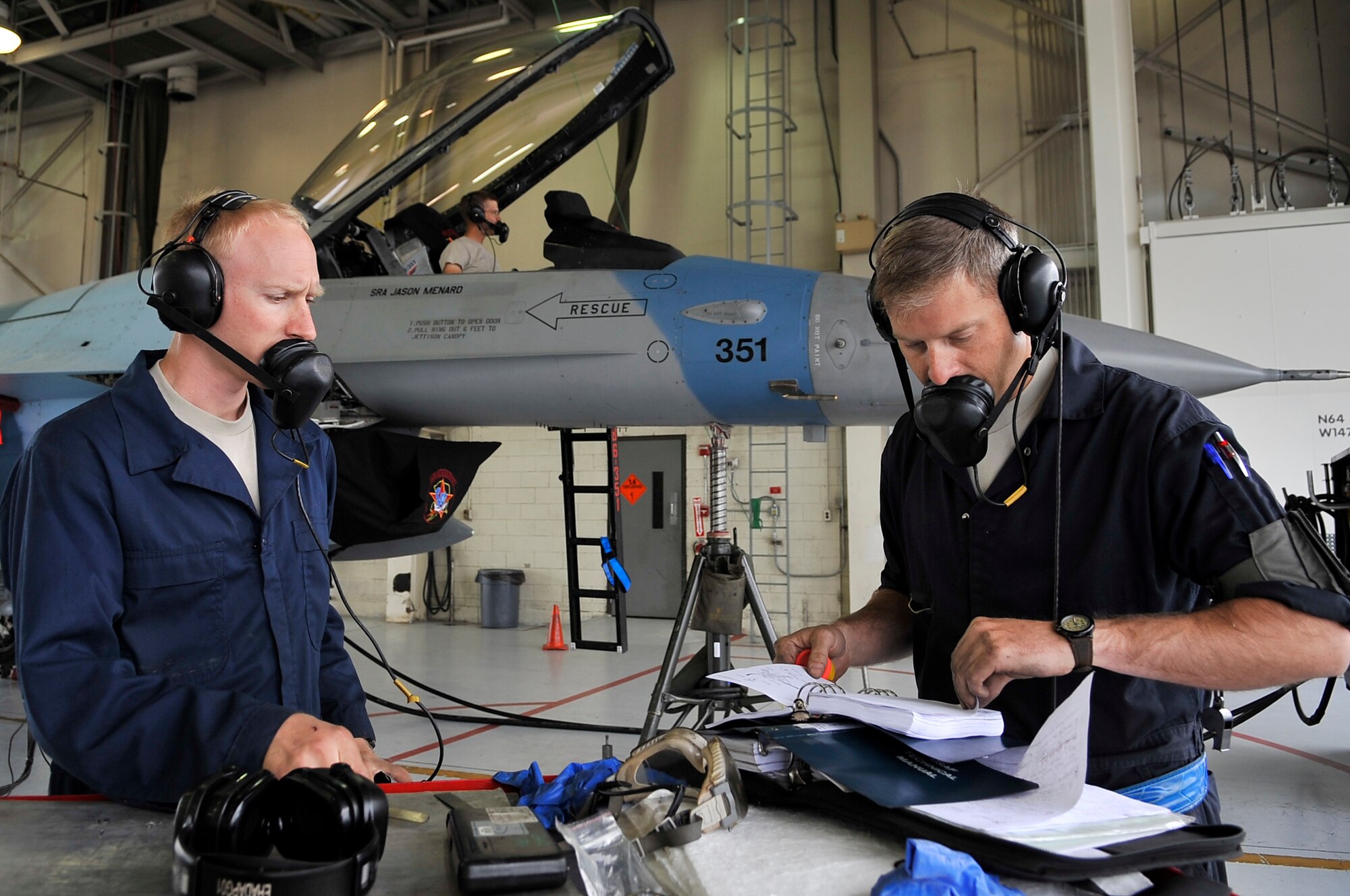 EIELSON AIR FORCE BASE, Alaska -- Staff Sgts. Gerald Ingram and Chris Harvey read training instructions for repairing landing gear on an F-16 Aggressor during NORTHERN EDGE 2009, June 19. NE09 is designed to sharpen skills, practice operations, techniques and procedures between the U.S. Military. Sergeants Ingram and Harvey are crew chiefs assigned to the 18th Aircraft Maintenance Unit. (U.S. Air Force photo/Staff Sgt. Christopher Boitz)