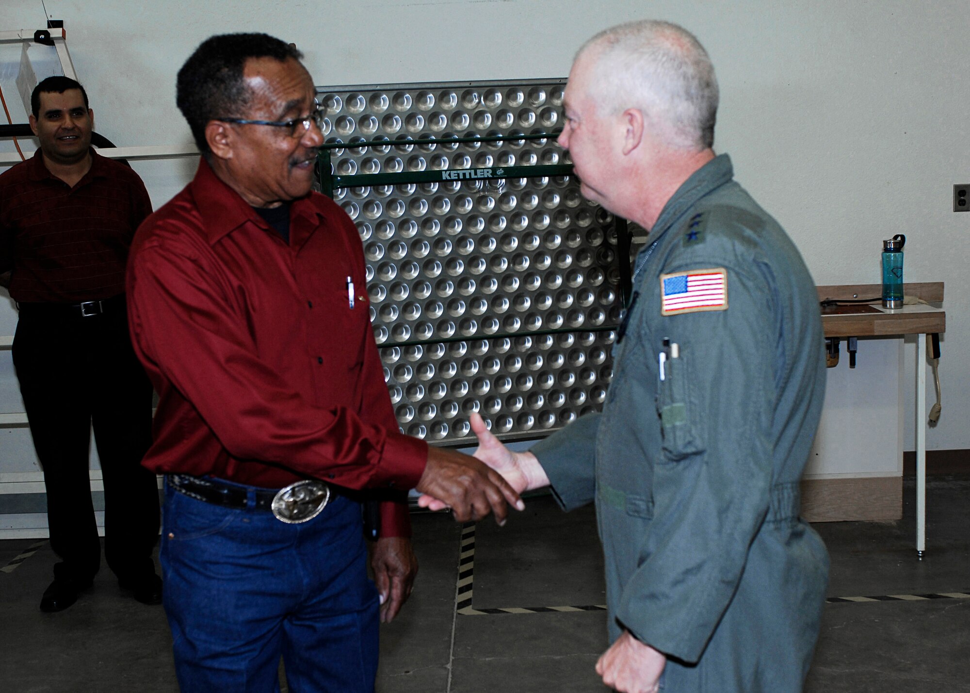 CANNON AIR FORCE BASE, N.M. -- Lt. Gen. Donald Wurster, Commander, Air Force Special Operations Command (right), shakes hands, presents a service pin and coins William Phipps, 27th Special Operations Civil Engineer Squadron for his 50 years of civil service June 19. Mr. Phipps  works as a mechanic on base. (U.S. Air Force photo by Danielle Powell)
