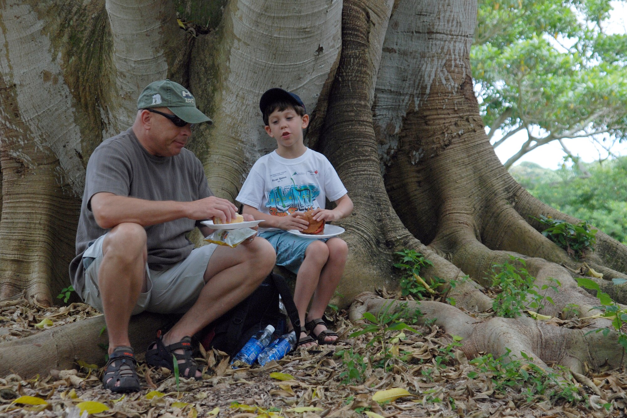KANEOHE, Hawaii -- Col. Russ Quinn, Pacific Air Forces Headquarters safety director, and his son Ryan, sat on the roots of an exotic tree in the gardens chatting about the fishing adventures they have been on in Australia and the main land and about the day's upcoming 10th Annual Keiki Fishing Tournament June 10 at the Ho'omaluhia Botanical Gardens. The keiki caught a record-setting 449 fish at the tenth annual tournament. The gardens are 400 acres of geographically laid out botanic garden of endangered and rare plants with a network of trails and a 32-acre lake. The name, Ho'omaluhia, translates "to make a place of peace and
tranquility." (U.S. Air Force photo/Staff Sgt. Mike Meares)

