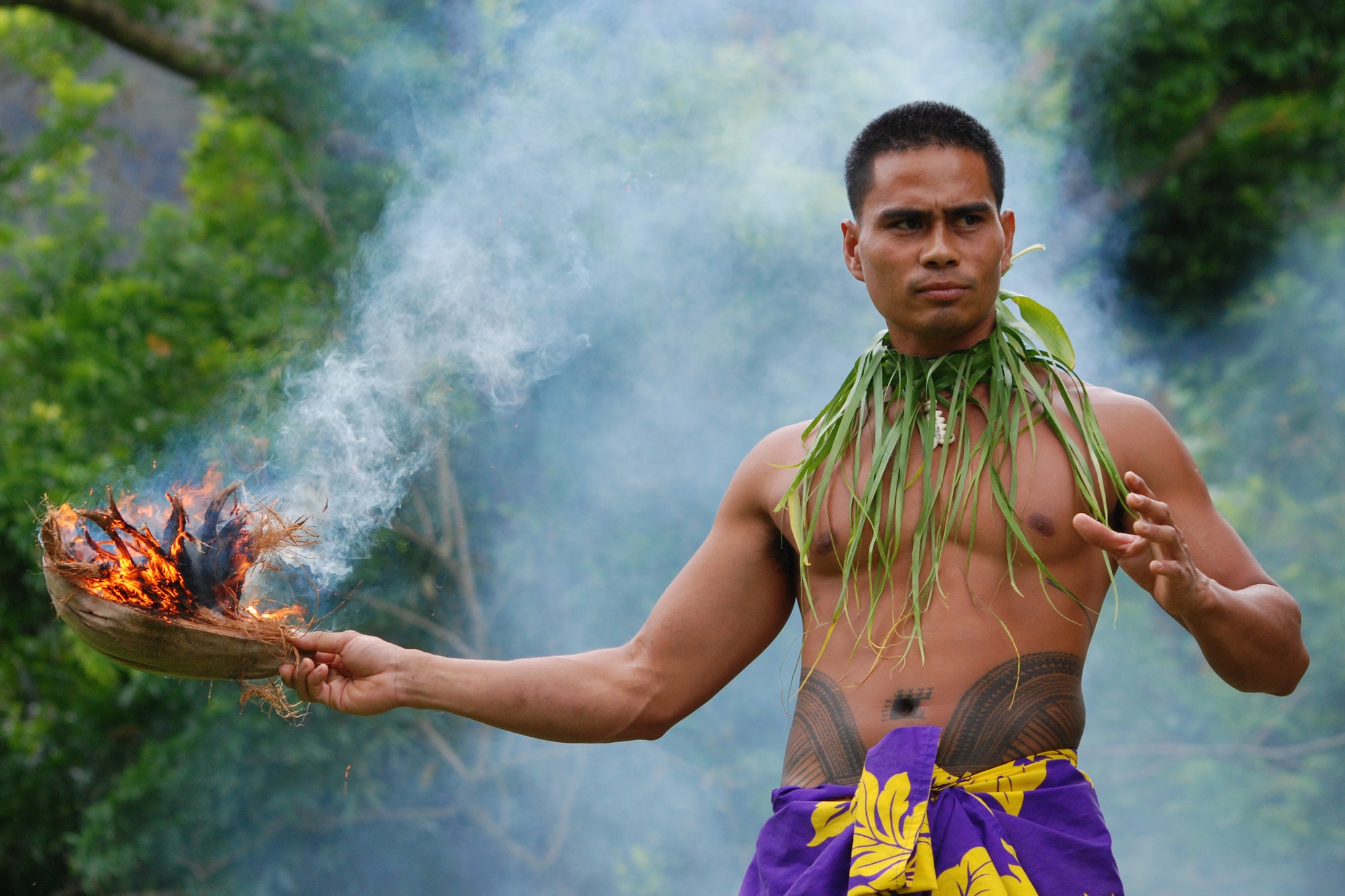 KANEOHE, Hawaii -- Chris Lifu, the Polynesian Cultural Center, wows the crowd with a demonstration of how the Samoan culture makes fire by rubbing two sticks together during the Friends of Hickam Keiki Fishing Tournament June 10 at the Ho'omaluhia Botanical Gardens. He also demonstrated how easily they crack open a coconut, the difference between coconut juice and milk, and how the men do all the major cooking while the women shop. The keiki caught a record-setting 449 fish at the tenth annual tournament. The gardens are 400 acres of geographically laid out botanic garden of endangered and rare plants with a network of trails and a 32-acre lake. The name, Ho'omaluhia, translates "to make a place of peace and tranquility." (U.S. Air Force photo/Staff Sgt. Mike Meares)


