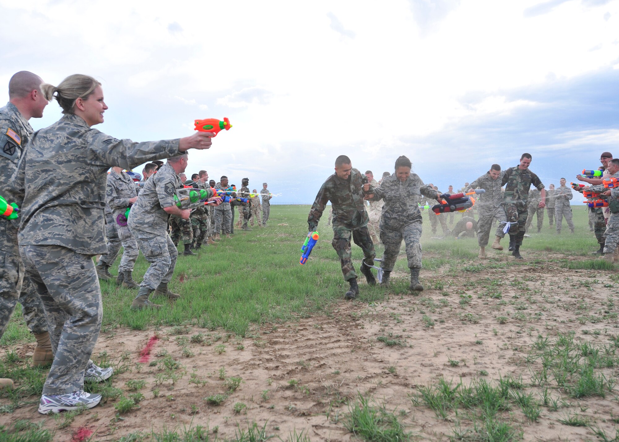 BUCKLEY AIR FORCE BASE, Colo. -- Two Airmen make their way through a line of water gun fire from other participants at the Combat Dining-in May 29 at Camp Rattlesnake here. More than 100 people showed up for the event. (U.S. Air Force photo by Senior Airman Alex Gochnour)