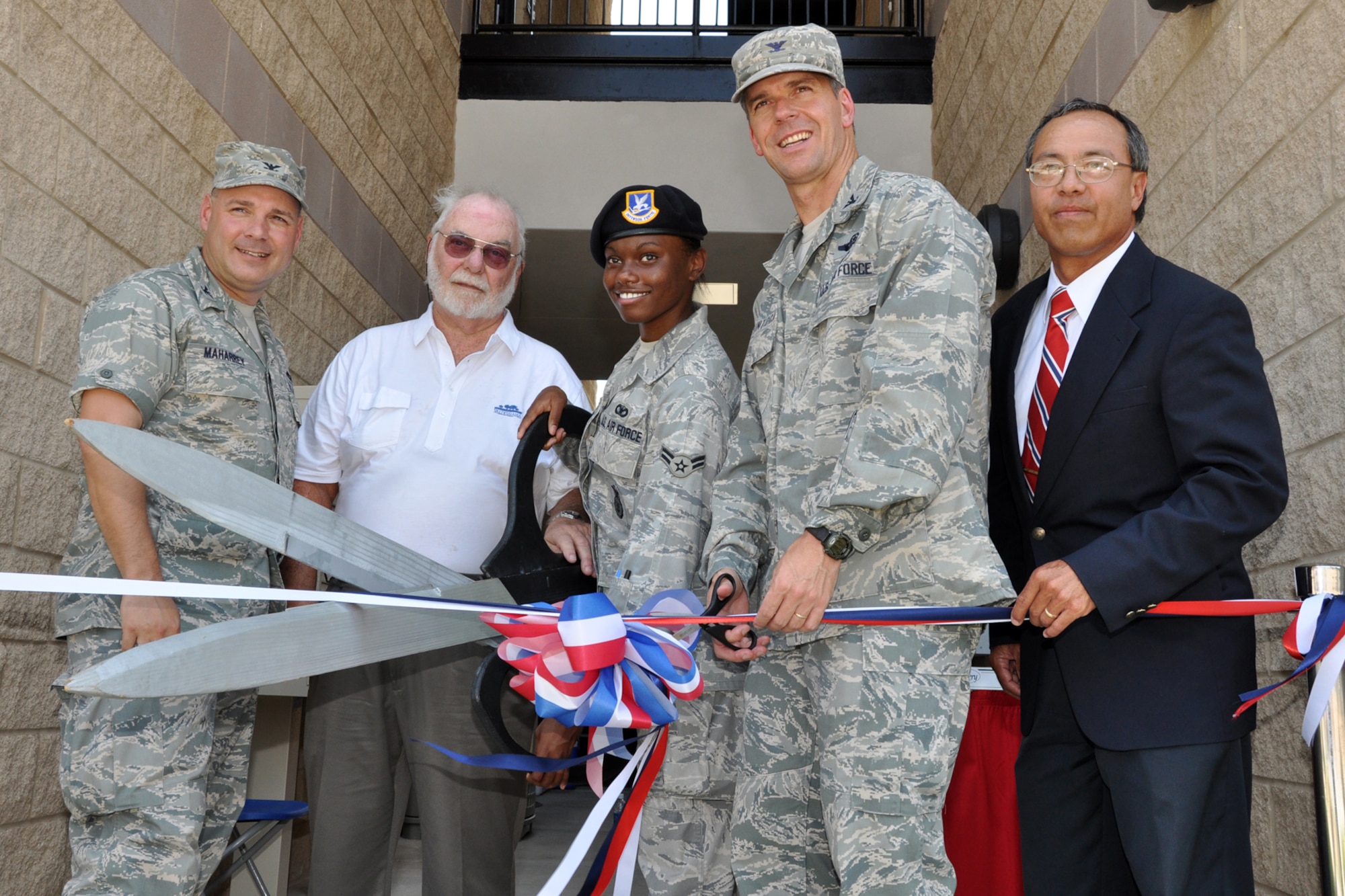 EGLIN AIR FORCE BASE, Fla. -- (From left) Col. David Maharrey, 96th Civil Engineer Group commander, Airman 1st Class Tamtra Chaison, 96th Security Forces Squadron, and Col. Bruce McClintock, 96th Air Base Wing commander cut the cermonial ribbon. The completion of the three-quad Dorm 18 was commemorated June 18, with a ribbon cutting ceremony followed by a tour of the rooms. Airmen from the 96th Security Forces Squadron and 96th Civil Engineer Group will be the first to occupy the new quad dorms.The The total cost of construction of the three dorm complex topped 13.5 million and the 96th Air Base Wing invested $10,000 in quality of life items like individual air control for each room and individual refrigerators. (U.S. Air Force photo/ Airman Anthony Jennings)