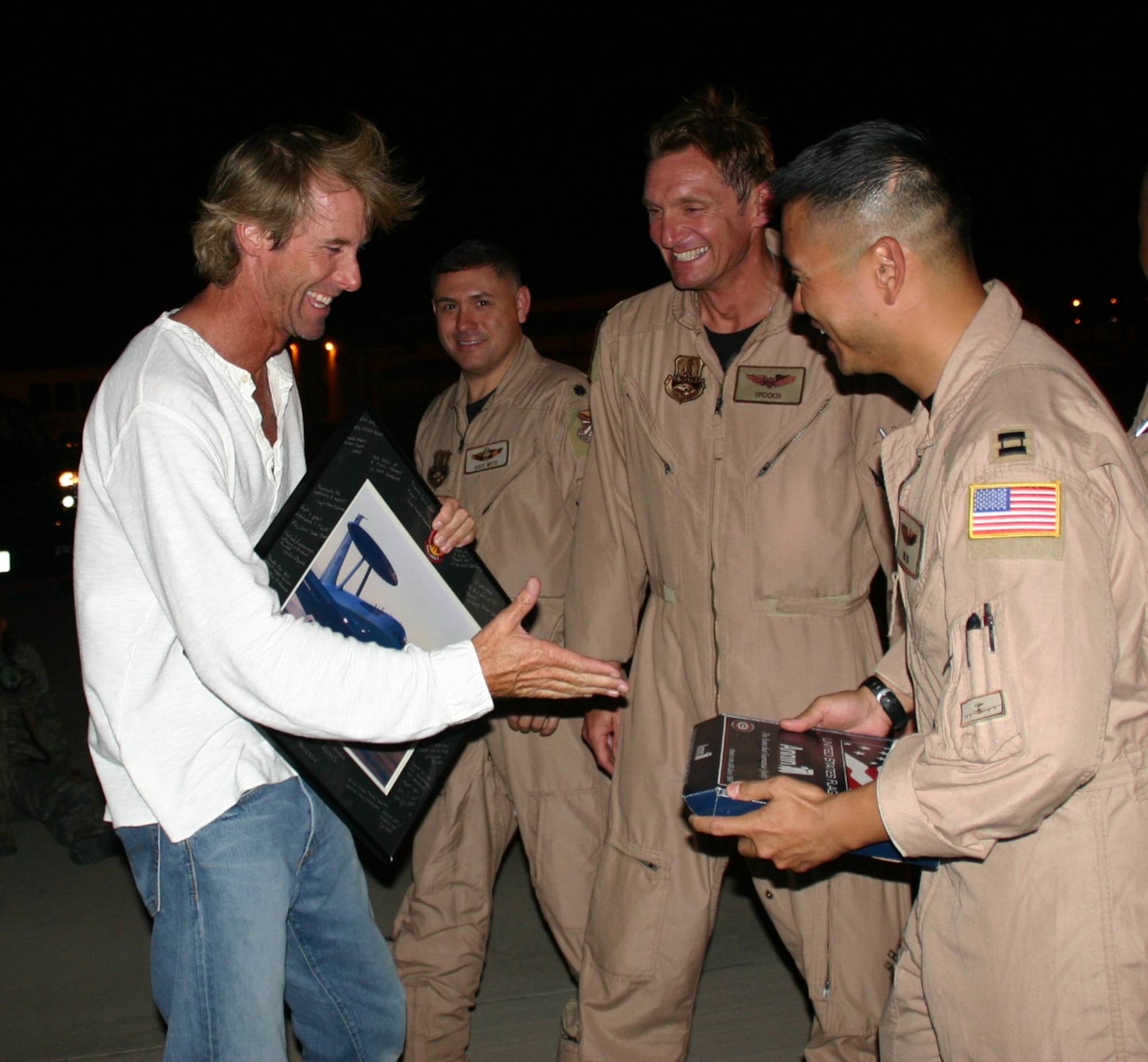 As a token of appreciation, after filming on the E-3, Lt. Col. Jimmy Warren and Capt. Thomas Ikehara present Michael Bay, director of “Transformers: Revenge of the Fallen,” with a framed picture of the E-3 and a flag flown on the jet during a combat sortie. Photo courtesy of 1st Lt. Kinder Blacke.