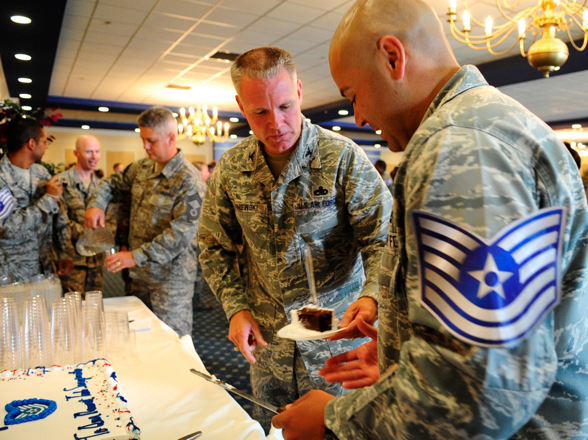 LANGLEY AIR FORCE BASE, Va. - Col. George Zaniewski, 1st Maintenance Group commander and Tech. Sgt. select Jose Velazquez Morales, 1st Communications Squadron cut the cake during the Technical Sergeant Select promotion party here June 18. More than 170 Staff Sgts. from the 1st Fighter Wing and Air Combat Command came together to celebrate the notification of their promotion to Technical Sergeant. (U.S. Air Force photo/Senior Airman Dana Hill)