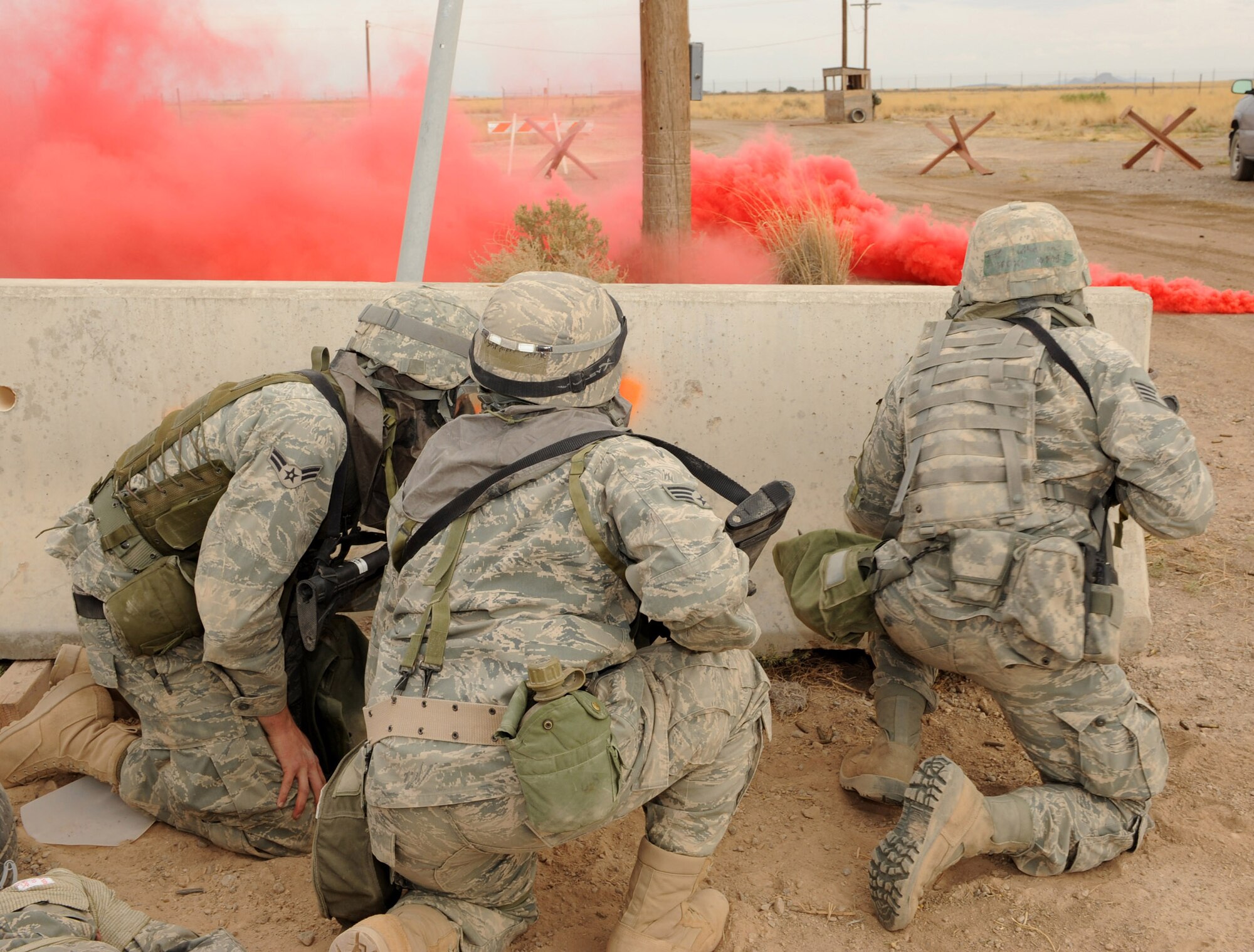 Airmen from Holloman Air Force Base, N.M., crouch for cover during a simulated ground attack on the Civil Engineer Pit, June 18, during exercise Coronet Gold Rush 09-06. The Airmen were performing security when opposing forces tried to gain access to the base through a simulated fire fight. The scenario ended when the opposition surrendered. (U.S. Air Force photo/Airman 1st Class Sondra Escutia)