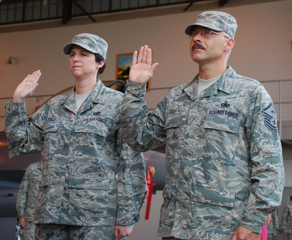 Master Sgts. Dana and Scotty Fogle take the oath of enlistment at their dual re-enlistment June 19 at the Hangar 1040. Sergeant Scotty Fogle is the 362nd Training Squadron first sergeant and his wife, Sergeant Dana Fogle, is the 82nd Civil Engineer Squadron acting first sergeant. (U.S. Air Force photo/ Airman 1st Class Valerie Hosea)