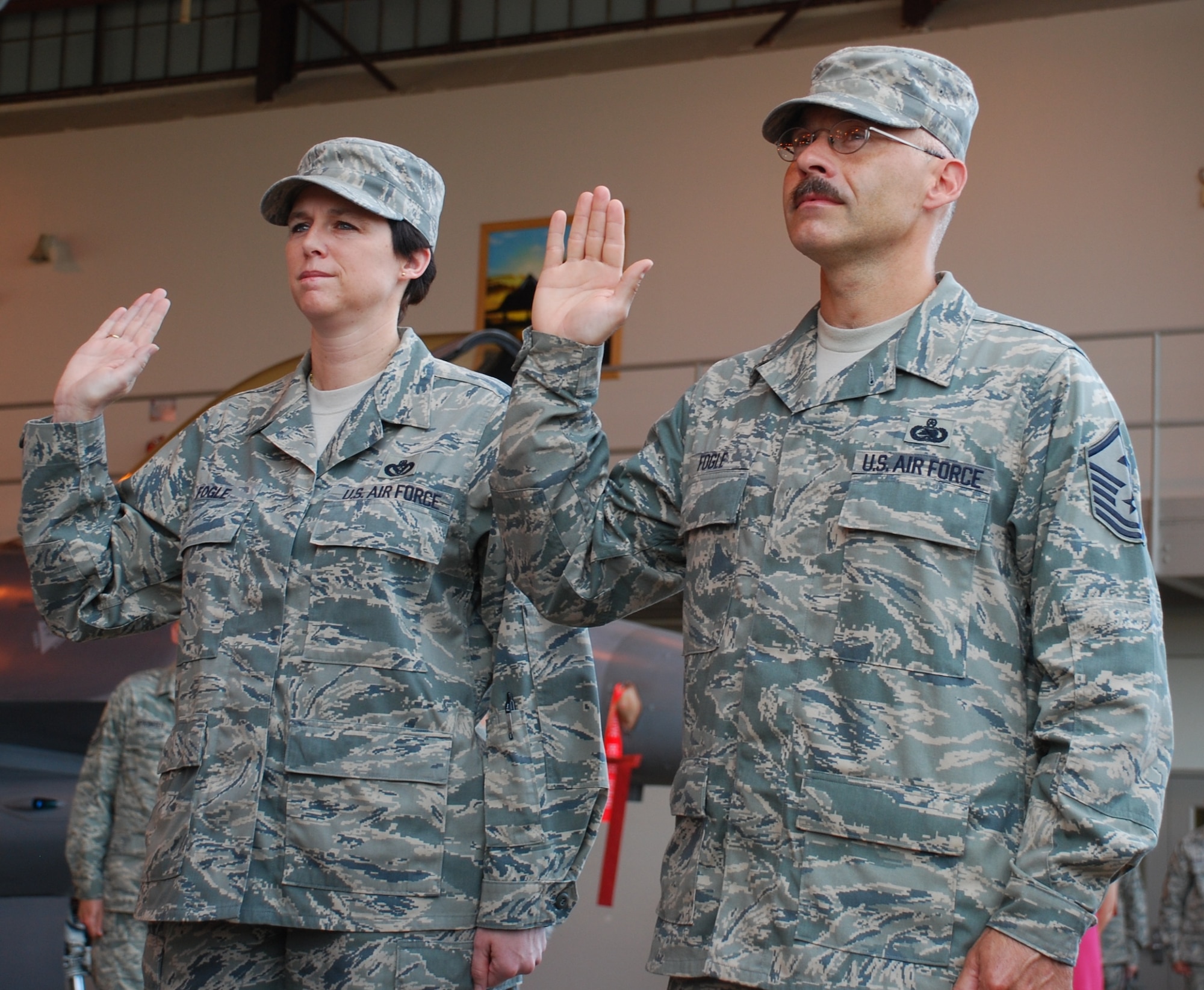 Master Sgts. Dana and Scotty Fogle take the oath of enlistment at their dual re-enlistment June 19 at the Hangar 1040. Sergeant Scotty Fogle is the 362nd Training Squadron first sergeant and his wife, Sergeant Dana Fogle, is the 82nd Civil Engineer Squadron acting first sergeant. (U.S. Air Force photo/ Airman 1st Class Valerie Hosea)