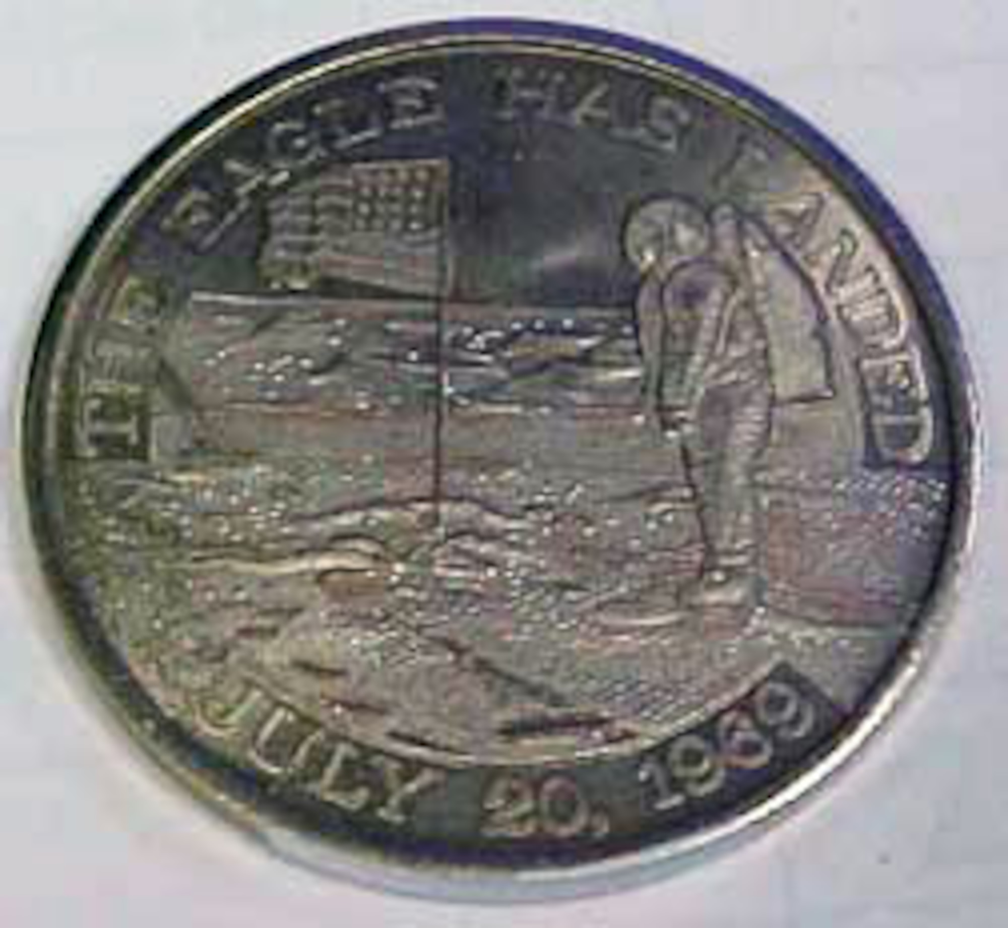 This coin commemorating the Apollo 11 mission shows an astronaut with an American flag standing on the moon's surface, along with the words "The Eagle has landed, July 20, 1969." The coin contains metal from spacecrafts Columbia and Eagle. (U.S. Air Force photo)