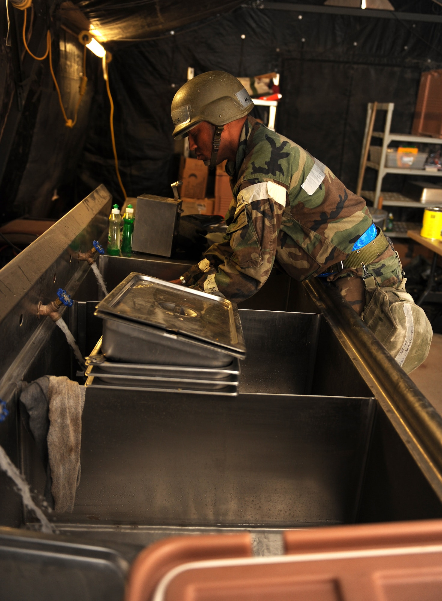 Master Sgt. Roland Cooper, 49th Force Support Squadron, prepares to do dishes using a sink that was part of the Single Pallet Expeditionary Kitchen at the Civil Engineer Pit, June 18, at Holloman Air Force Base, N.M. The 49 FSS set up the SPEK as a way for Airman participating the Phase II exercise to receive a hot meal. (U.S. Air Force photo/Airman 1st Class Sondra Escutia)