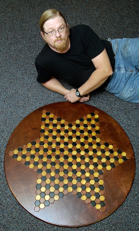 When not welding at Tinker, Mike Owen thinks chess. His idea that more than two could play the same chess game evolved and now waits for attorneys to patent his dream. His large, hand-made wooden gameboard accommodates six players. (Air Force photo by Margo Wright)