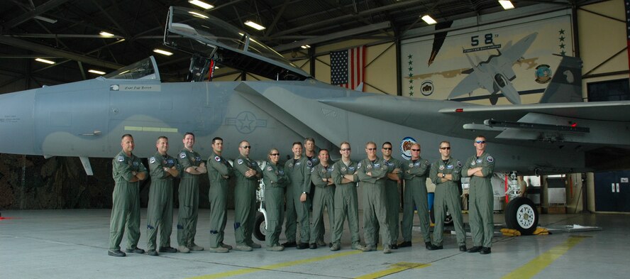 Fifteen of the last 20 pilots left at the 58th Fighter Squadron pose for a photo in front of an F-15 during their reunion June 18 at Eglin Air Force Base.  The week-long celebration gave past and present squadron members an opportunity to participate in social activities and reminice about their history while also saying good bye to 30 years of flying the F-15 as they transition to the F-35.(U.S. Air Force photo/ Chrissy Cuttita.)