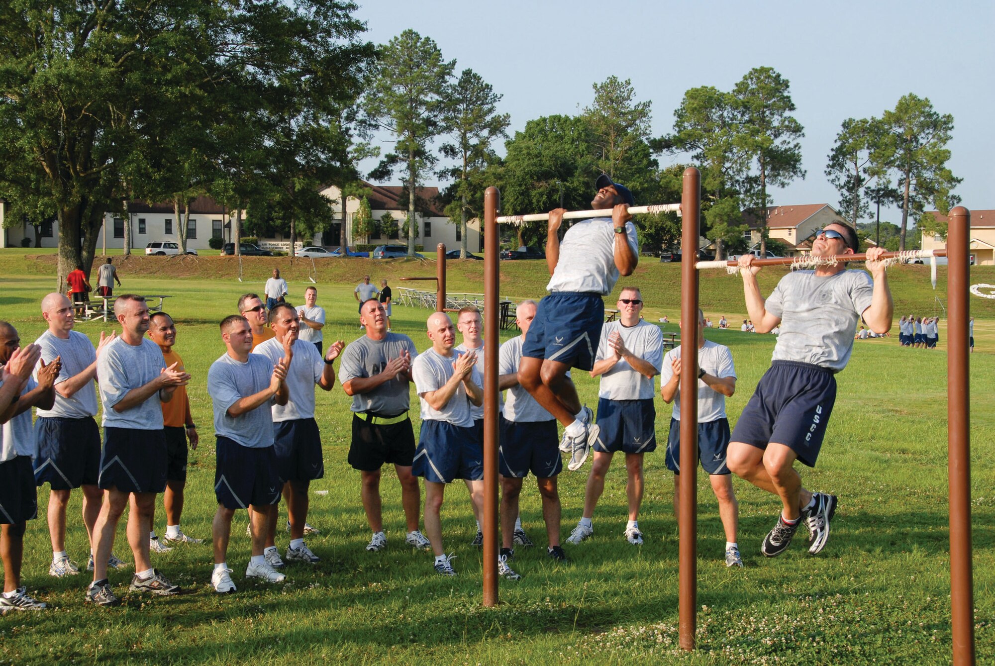 Airmen and "guardian" from "Ravens 3" at the Senior NCO Academy perform the pull-up exercise after a 3-mile run during fitness training as fellow students and instructors cheer them on. (U.S. Air Force photo/Bud Hancock) 