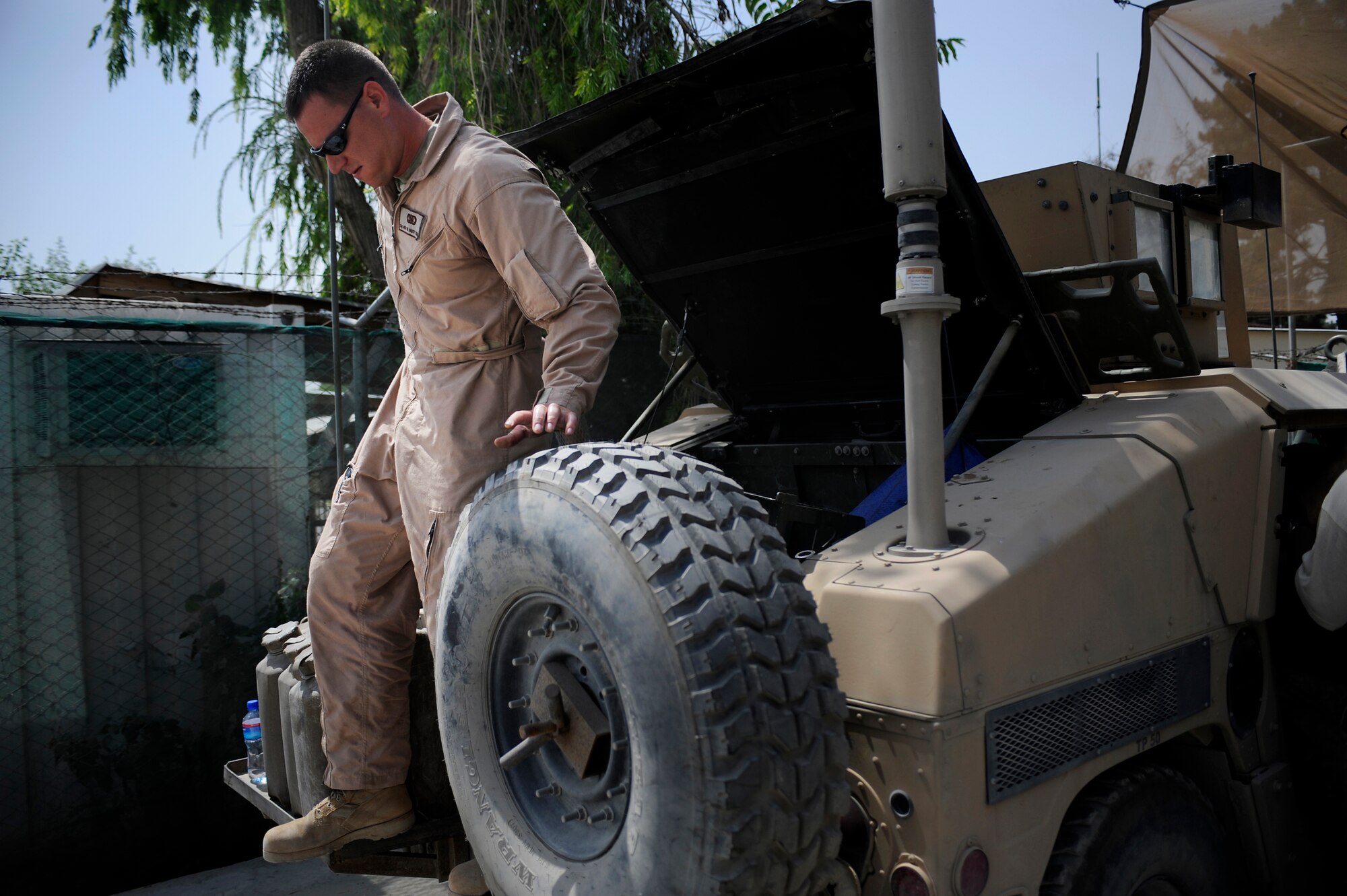 Staff Sgt. Josh Newman, Satellite Systems Specialist, Nangarhar Provincial Reconstruction Team, performs routine maintenance on a Mine Resistant Ambush Protected Vehicle May 30, 2009, at Forward Operating Base Fenley-Shields, Afghanistan. The PRT is responsible for development and reconstruction projects in Nangarhar Province. The projects are built by local contractors and are designed to improve the livelihood of the people living in the area. Newman is deployed from the 6th Communications Squadron, MacDill Air Force Base, Fla.  (U.S. Air Force Photo by Staff. Sgt. Shawn Weismiller)