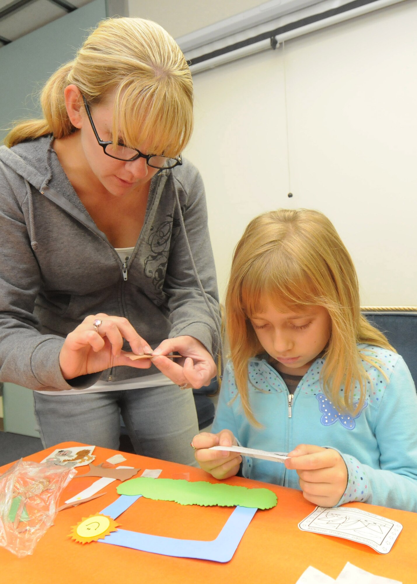 YOKOTA AIR BASE, Japan -- Victoria Brandhorst and her mother Cindy read step-by-step directions for creating a picture frame during an Australian-themed craft day at the library's summer reading program, June 18. Each year the Air Force conducts a summer reading program for children of military members to help improve their reading proficiency. This year's theme is Book-A-Trip: Read Around the World. (U.S. Air Force photo/Staff Sgt. Veronica Pierce)