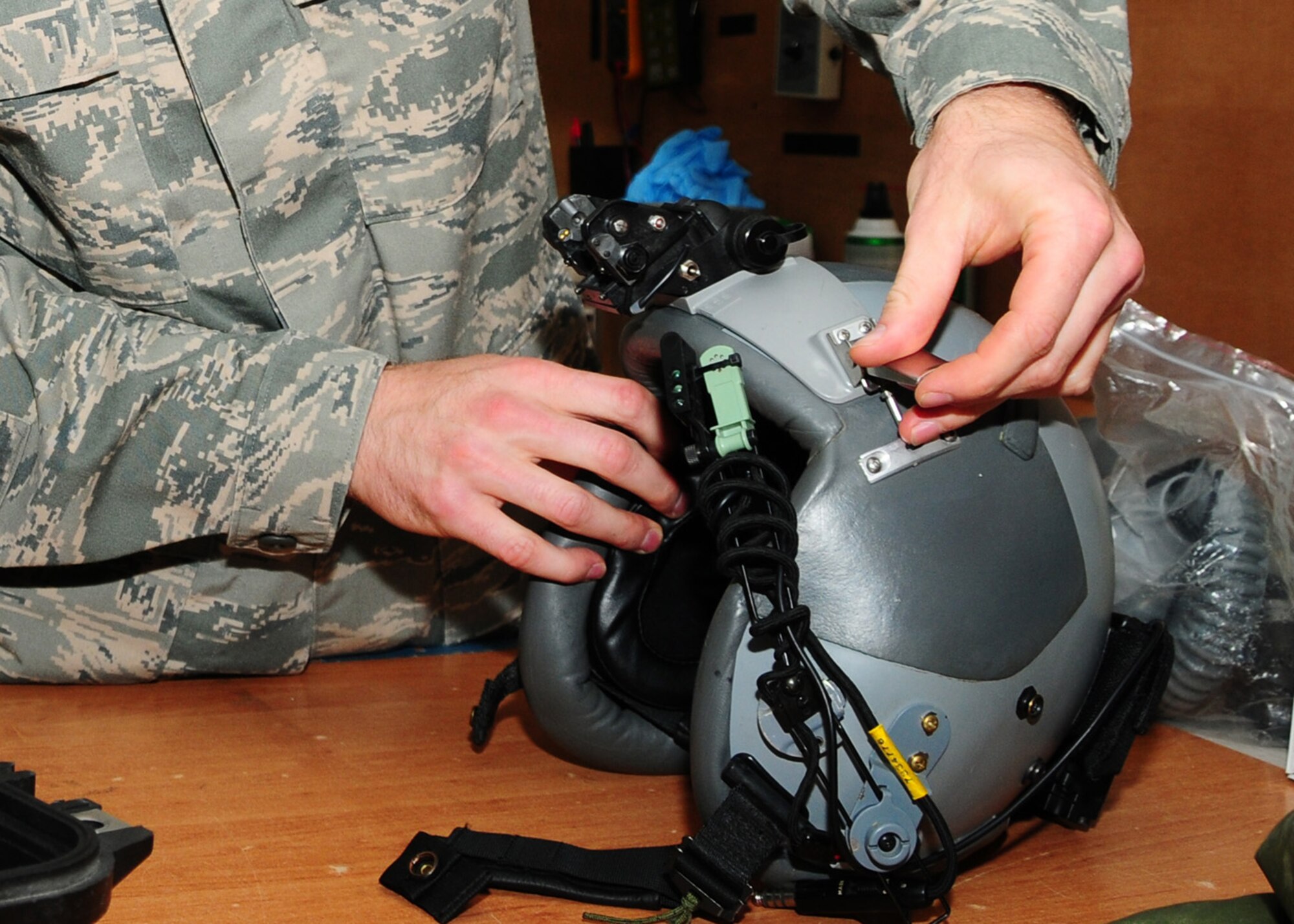 SOUTHWEST ASIA -- Tech. Sgt. Nathan Schasse, 817th Expeditionary Airlift Squadron, snaps the night vision goggle mounting clip onto a aircrew helmet at an air base in Southwest Asia, June 18. The NVG's must be centered properly on the helmet to create the best fit for the aircrew and  to allow the user to get the most range of adjustment. Sergeant Schasse is deployed from McChord Air Force Base, Wash., and is originally from Madison, Wis. (U.S. Air Force photo/Senior Airman Courtney Richardson)