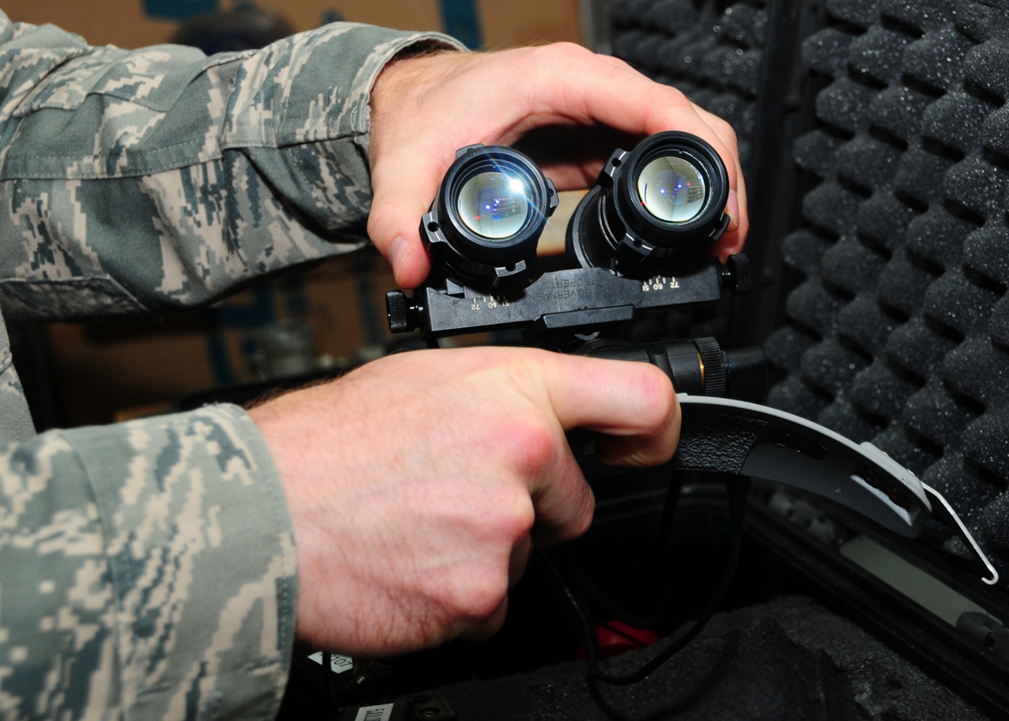 SOUTHWEST ASIA -- Tech. Sgt. Nathan Schasse, 817th Expeditionary Airlift Squadron, folds a pair of night vision goggles up and down to ensure they lock in both upper and lower positions at an air base in Southwest Asia, June 18. Along with checking the locking positions the goggles are also checked to make sure they release properly from the helmet mount. Sergeant Schasse is deployed from McChord Air Force Base, Wash., and is originally from Madison, Wis. (U.S. Air Force photo/Senior Airman Courtney Richardson)