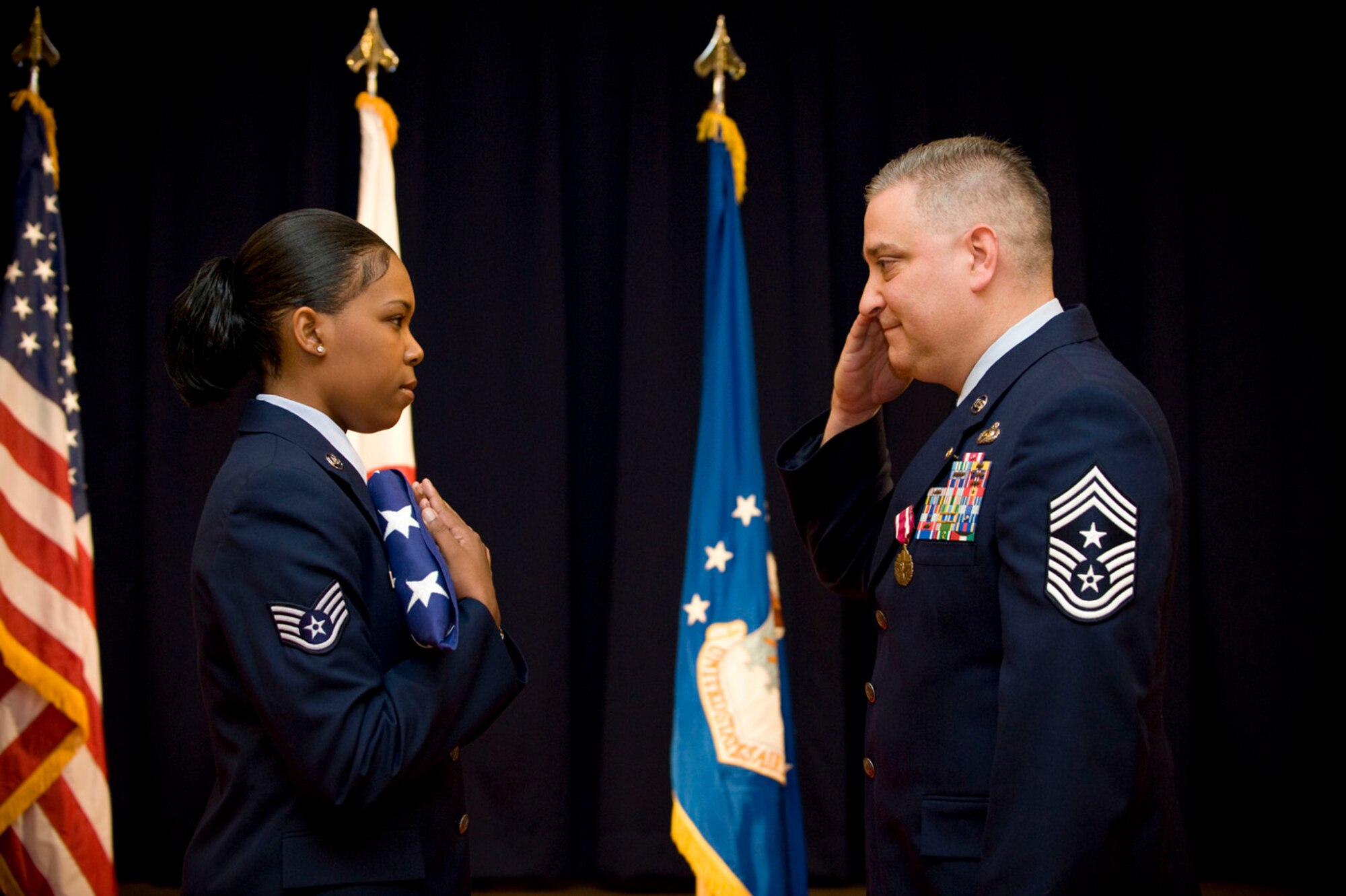 MISAWA AIR BASE, Japan -- Chief Master Sgt. Ricky Price gives a final salute to the American flag during his retirement ceremony June 19, 2009. Staff Sgt. Tiffany Arrington, bearing the flag, was one of the first people Chief Price met upon assuming the role of command chief master sergeant of the 35th Fighter Wing in 2008. (U.S. Air Force photo by Staff Sgt. Samuel Morse)