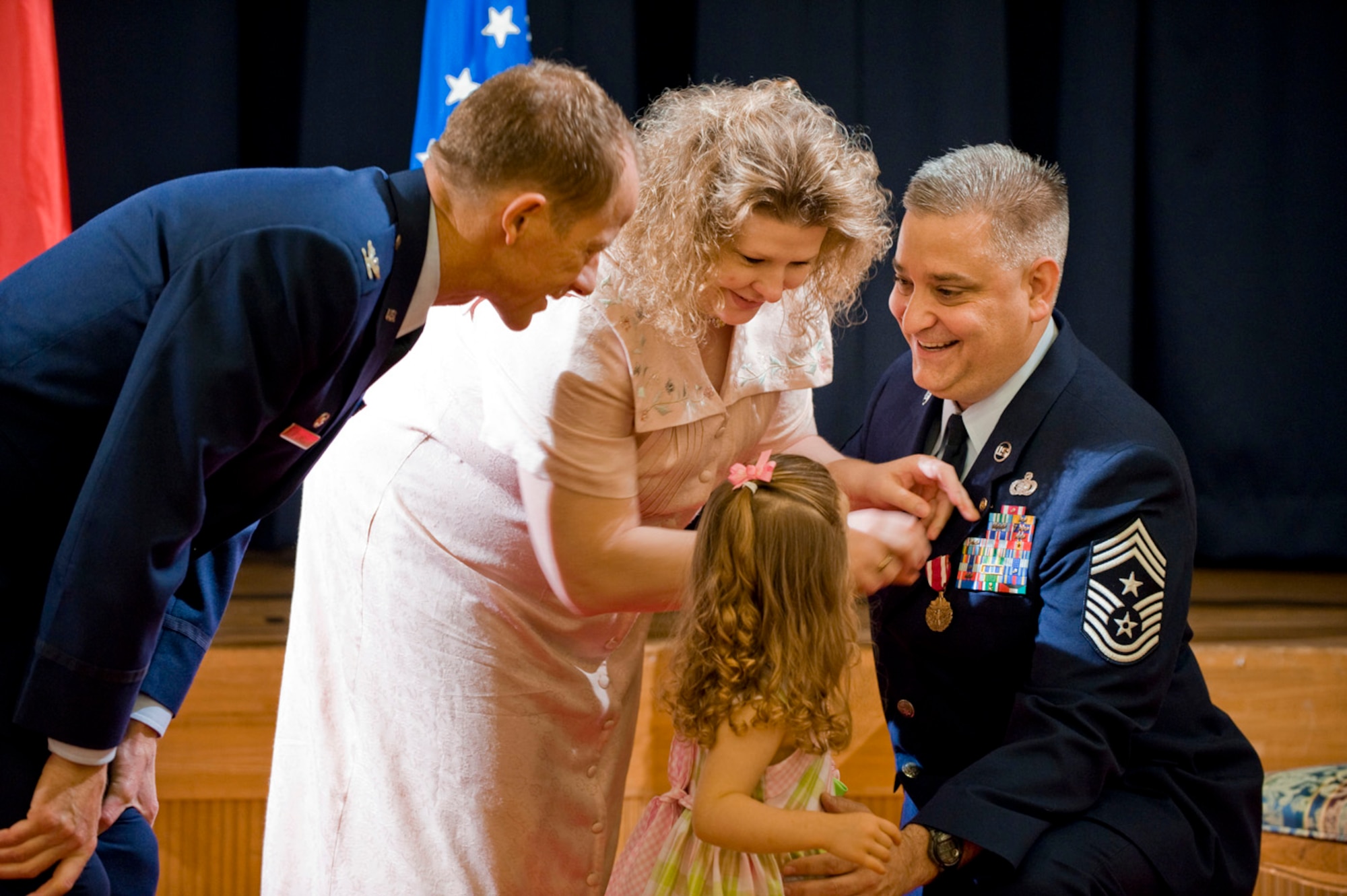 MISAWA AIR BASE, Japan -- Chief Master Sgt. Ricky Price receives a commemorative pin from his wife, Joan, and daughter, Makayla, signifying his retirement June 19, 2009. Chief Price served more than 25 years on active duty, finishing his career as command chief master sergeant, 35th Fighter Wing. (U.S. Air Force photo by Staff Sgt. Samuel Morse)
