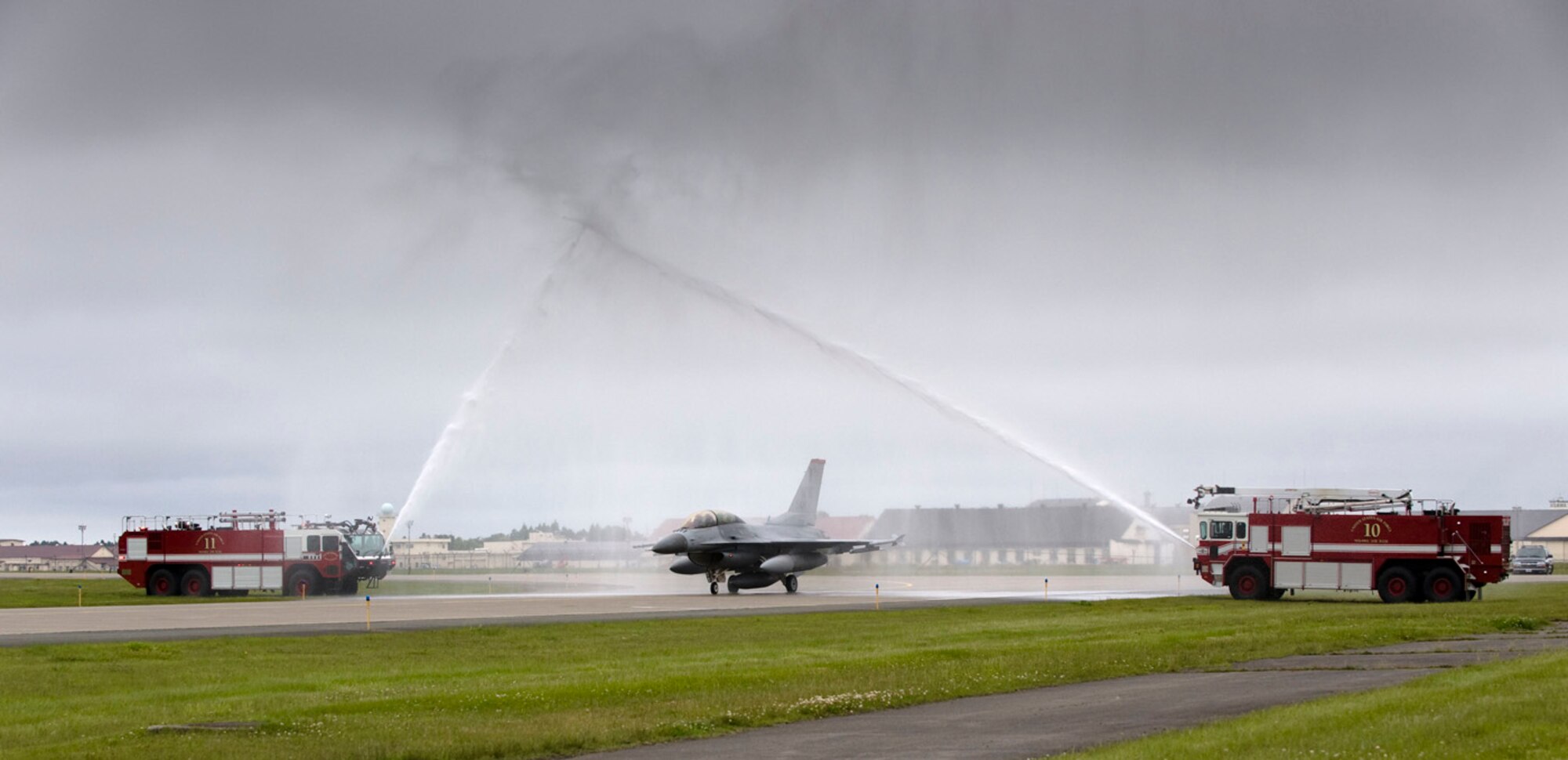 MISAWA AIR BASE, Japan -- Two fire trucks shower an F-16 Fighting Falcon as it leaves the tarmac June 15, 2009. A tradition normally reserved for pilots on their final flight, this shower commemorated Chief Master Sgt. Ricky Price, 35th Fighter Wing command chief master sergeant, on the week of his retirement. (U.S. Air Force photo by Staff Sgt. Samuel Morse)