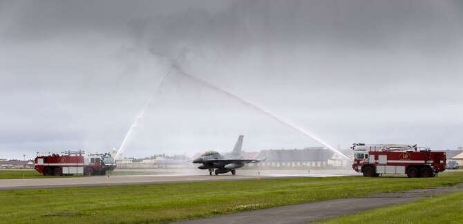 MISAWA AIR BASE, Japan -- Two fire trucks shower an F-16 Fighting Falcon piloted by Col. David Stilwell, 35th Fighter Wing commander, with Chief Master Sgt. Rick Price, 35th FW command chief, in the backseat June 15, 2009. Chief Price received an incentive flight to commemorate his retirement June 19, 2009. (U.S. Air Force photo by Staff Sgt. Samuel Morse)